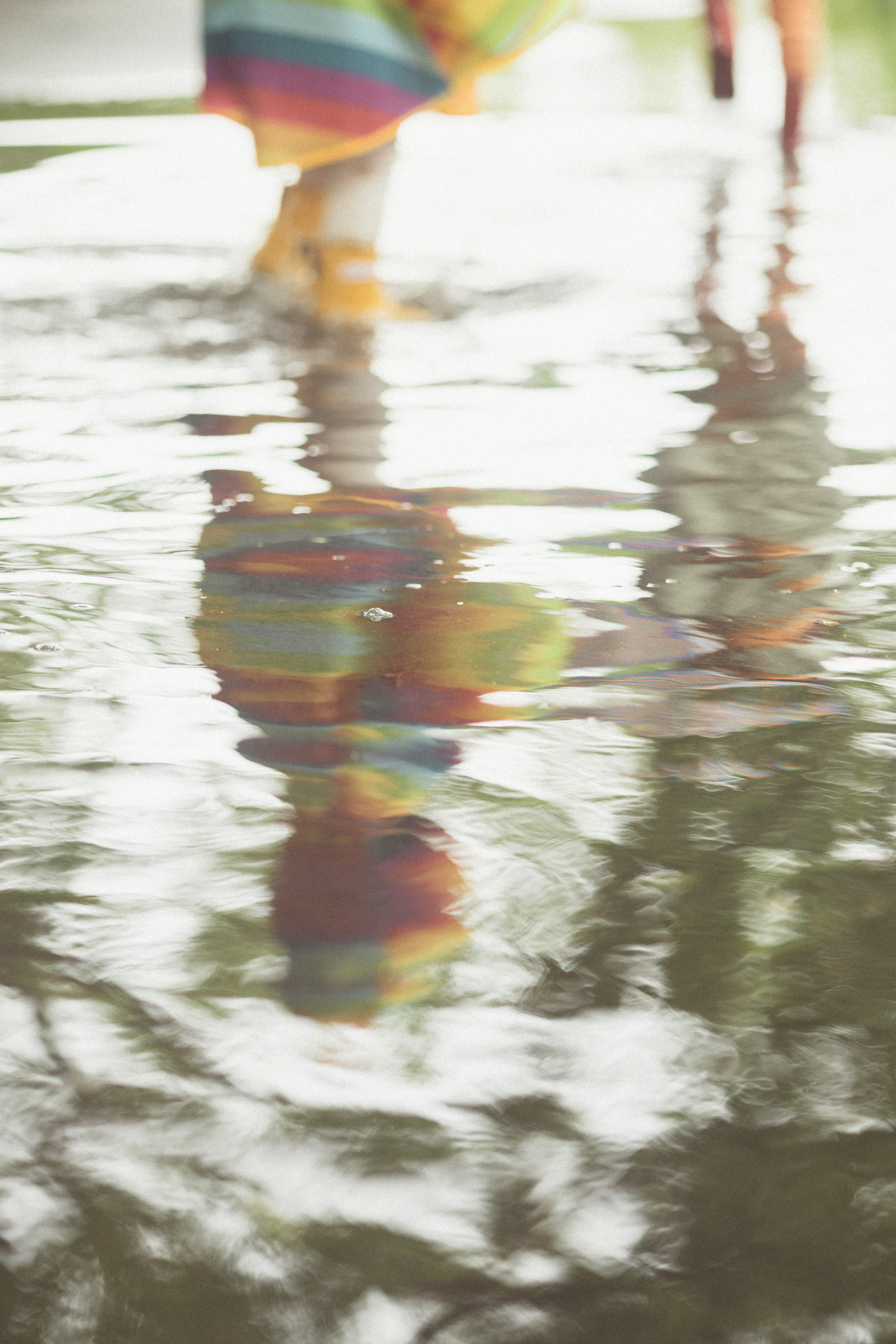 Reflexion einer Person in bunter Kleidung, die auf Wasser geht