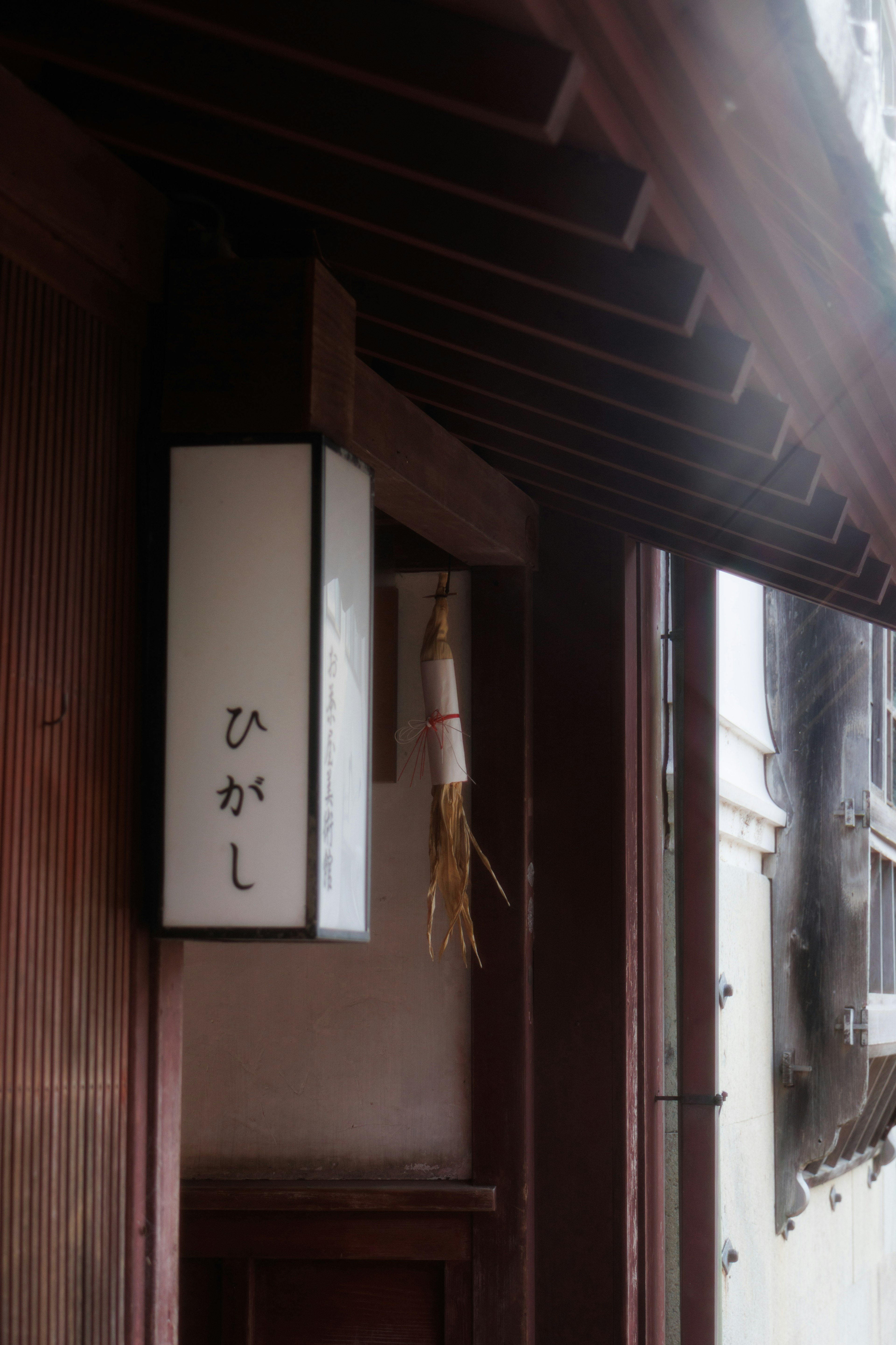 伝統的な日本の建物の入口にある白い提灯と竹の飾り