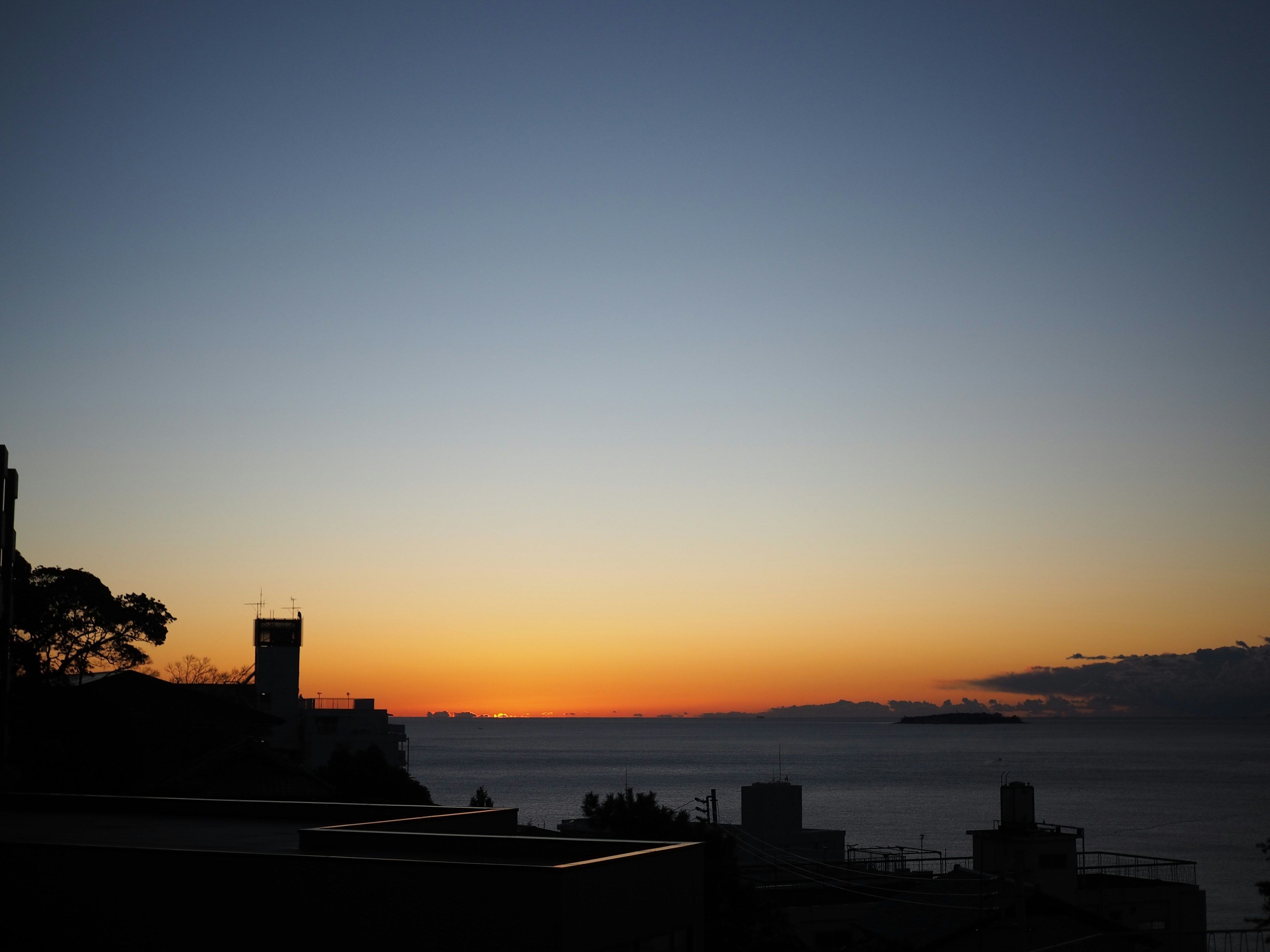 夕焼けと海の風景に建物のシルエット