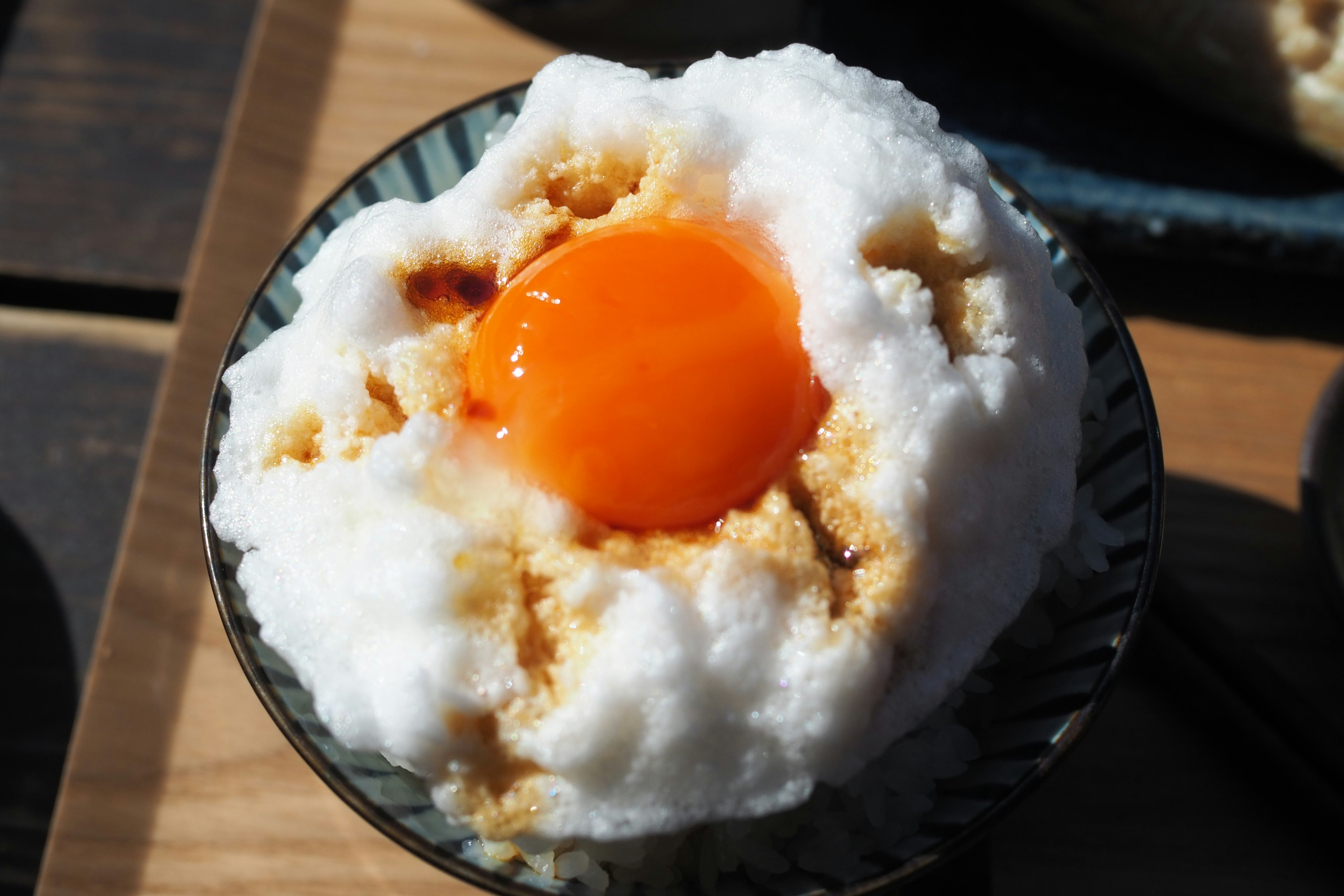 Un plato con una sustancia blanca esponjosa coronada con una yema de huevo naranja brillante