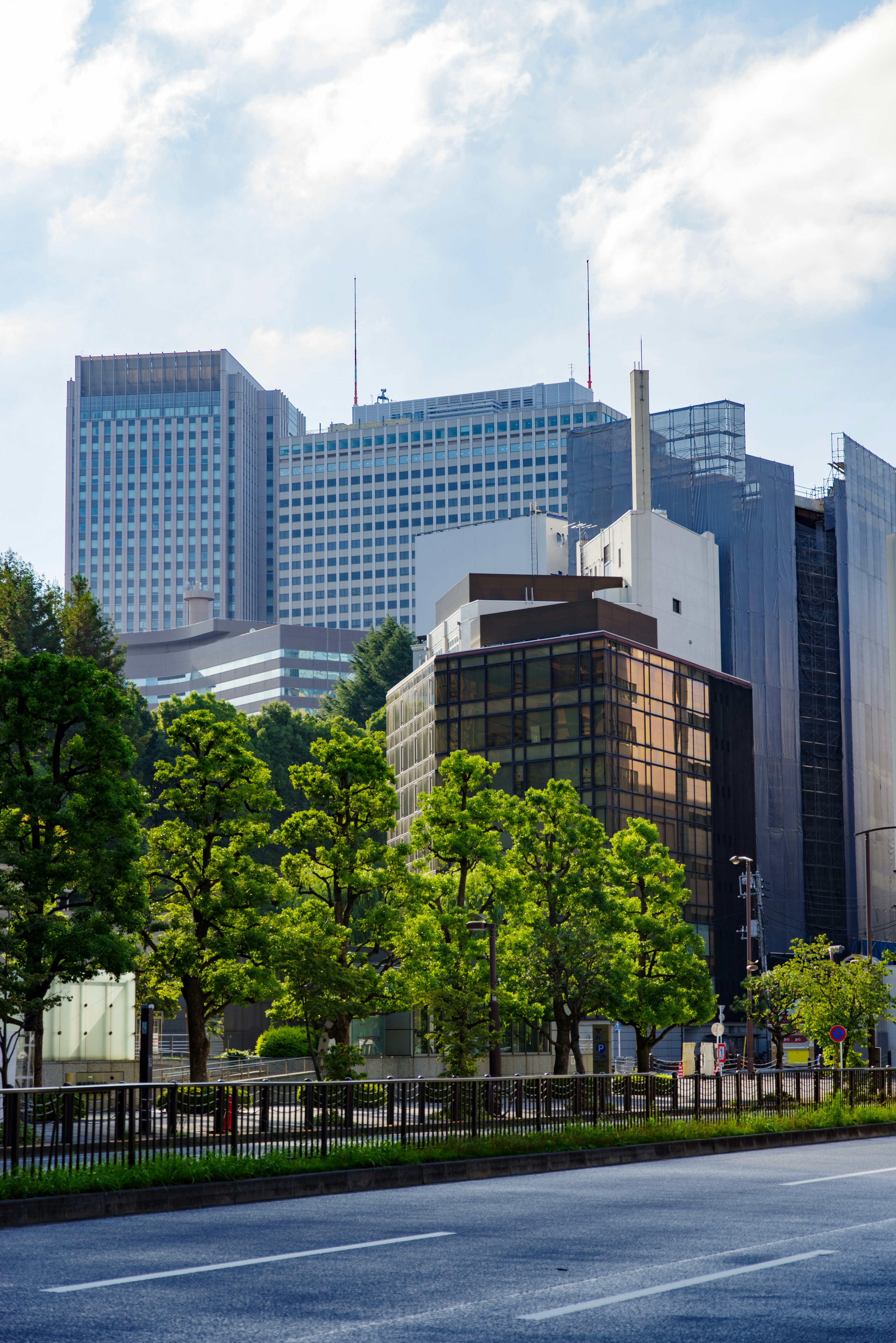 Cityscape featuring tall buildings and lush green trees