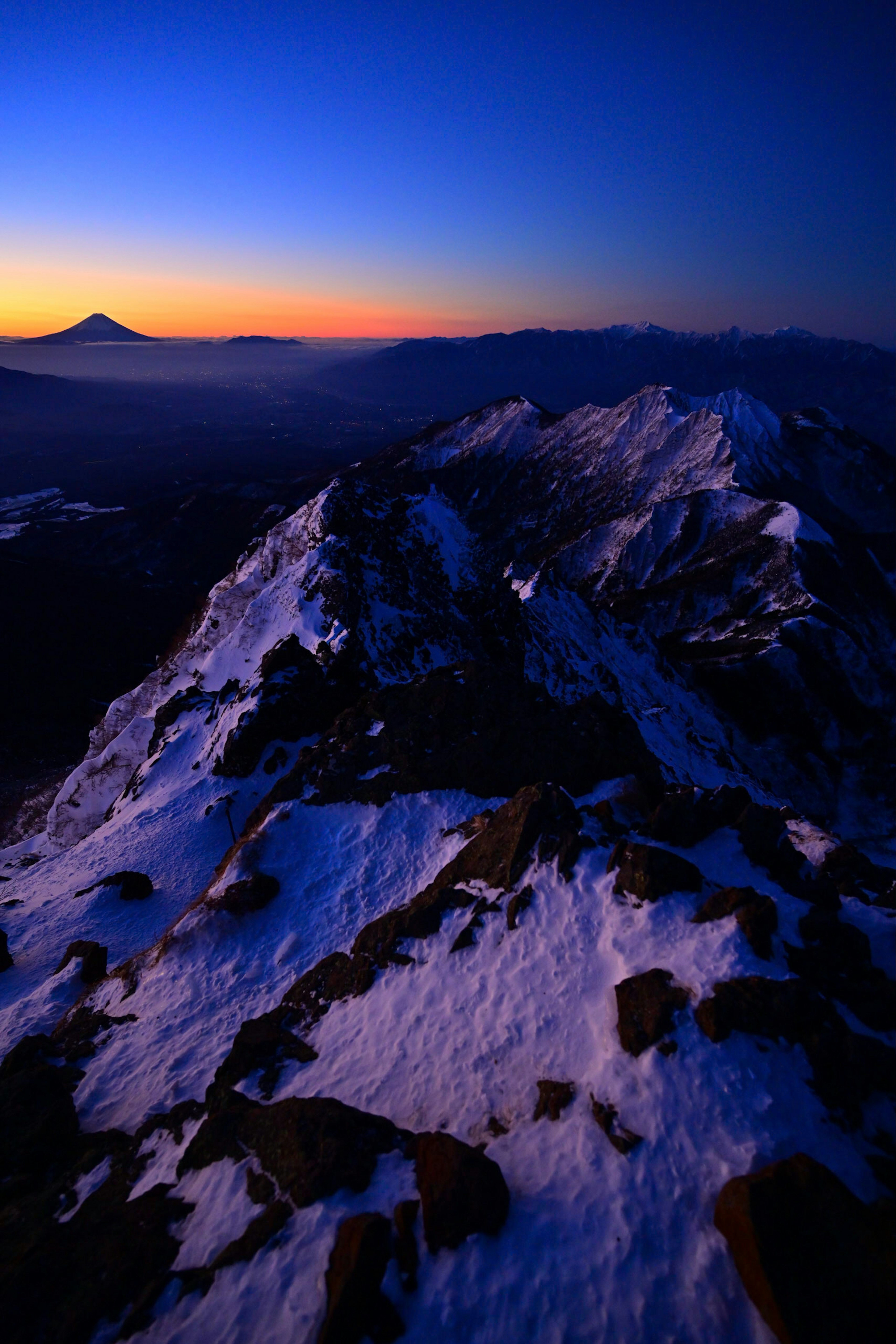 Catena montuosa coperta di neve con cielo crepuscolare