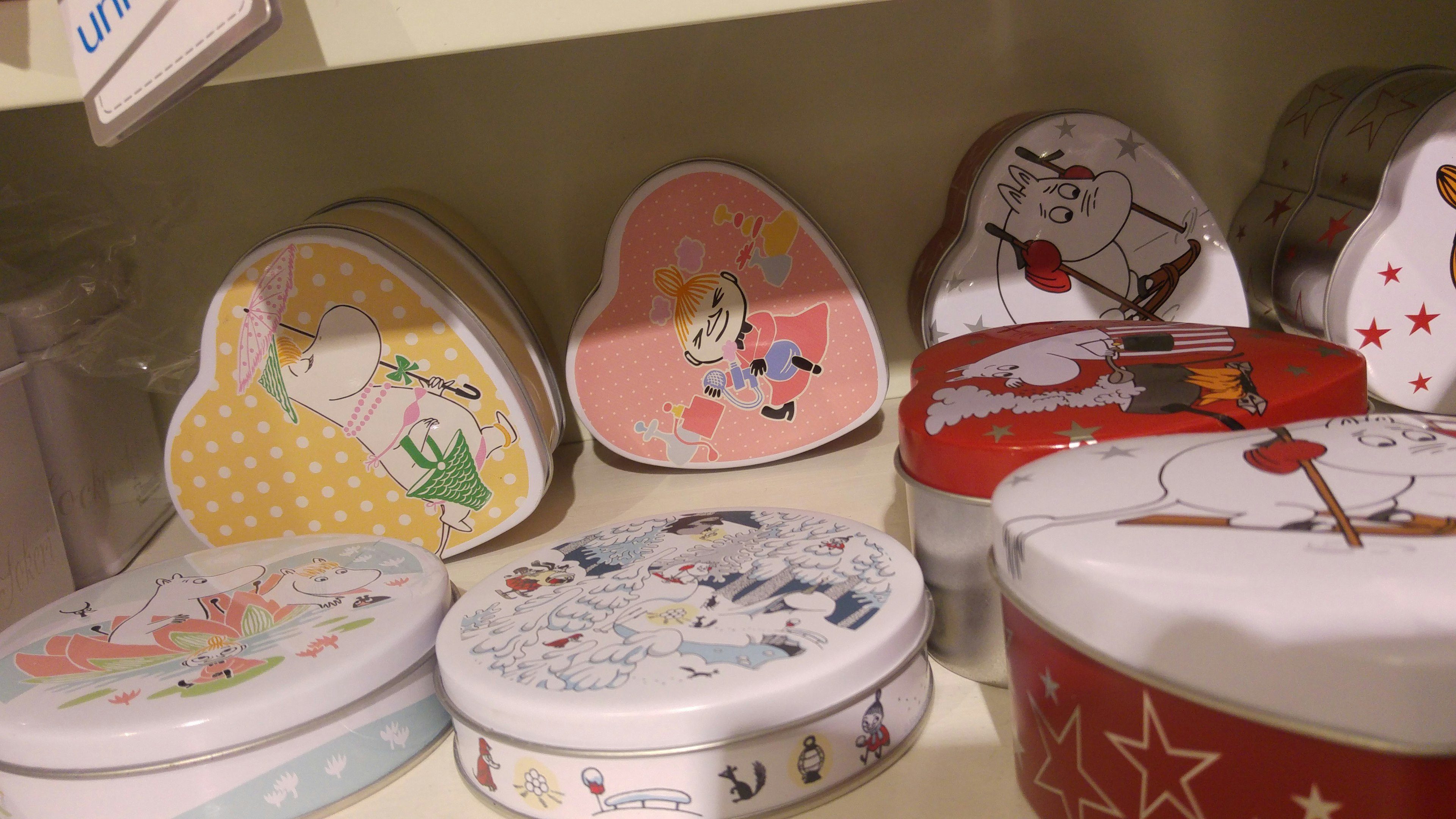 Colorful heart-shaped and round tins displayed on a shelf