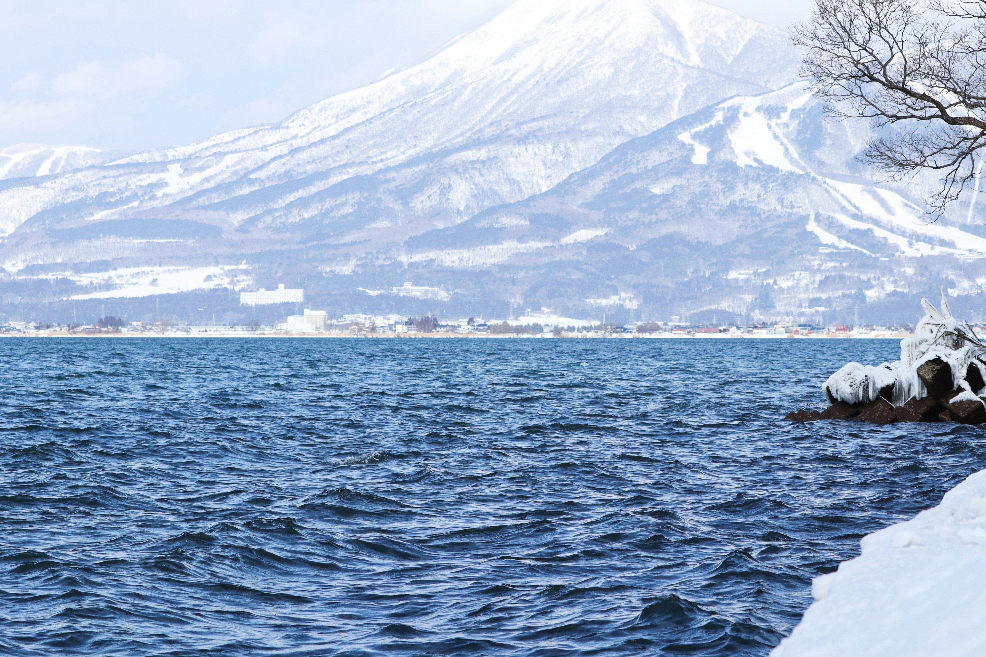 Scenic view of a snow-covered mountain and blue lake