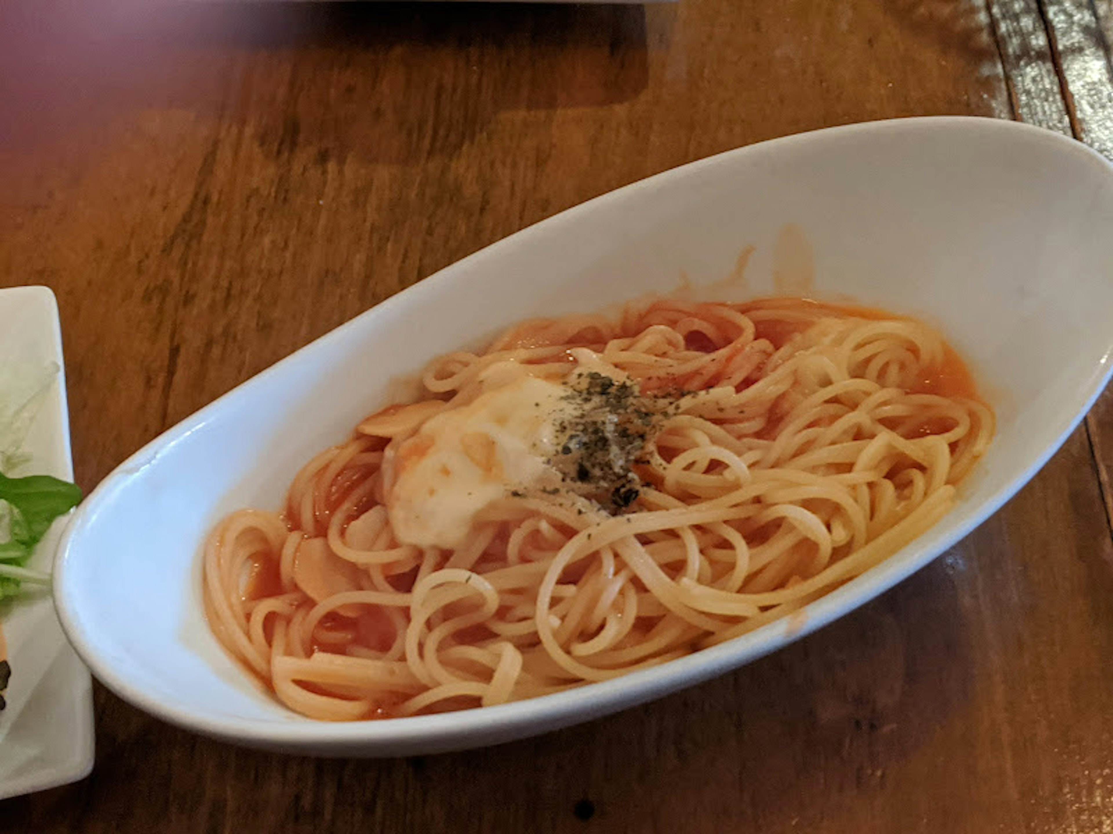 Spaghetti dengan saus tomat krim disajikan di piring putih