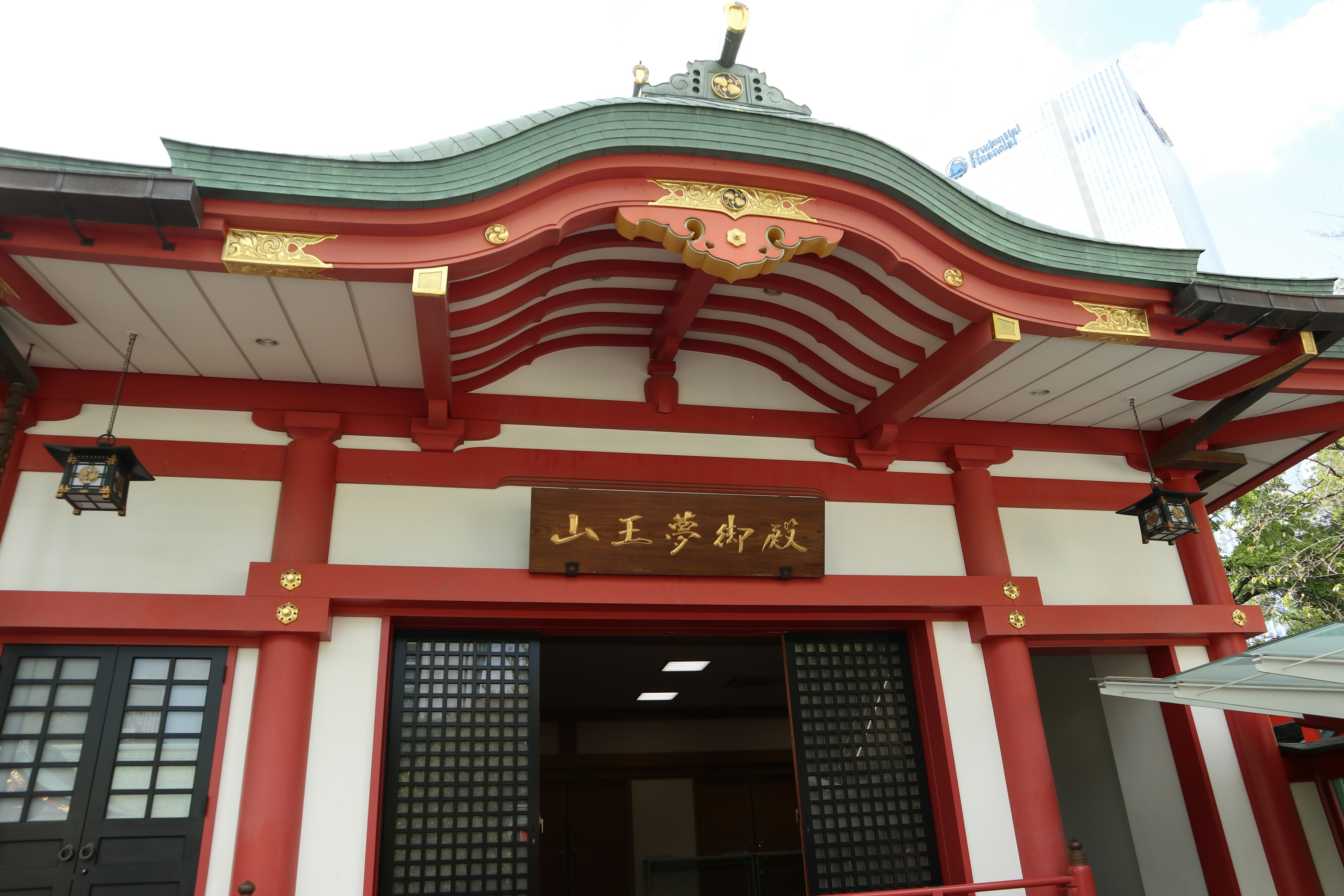 Entrance of a shrine with a red roof featuring an eye-catching kanji sign