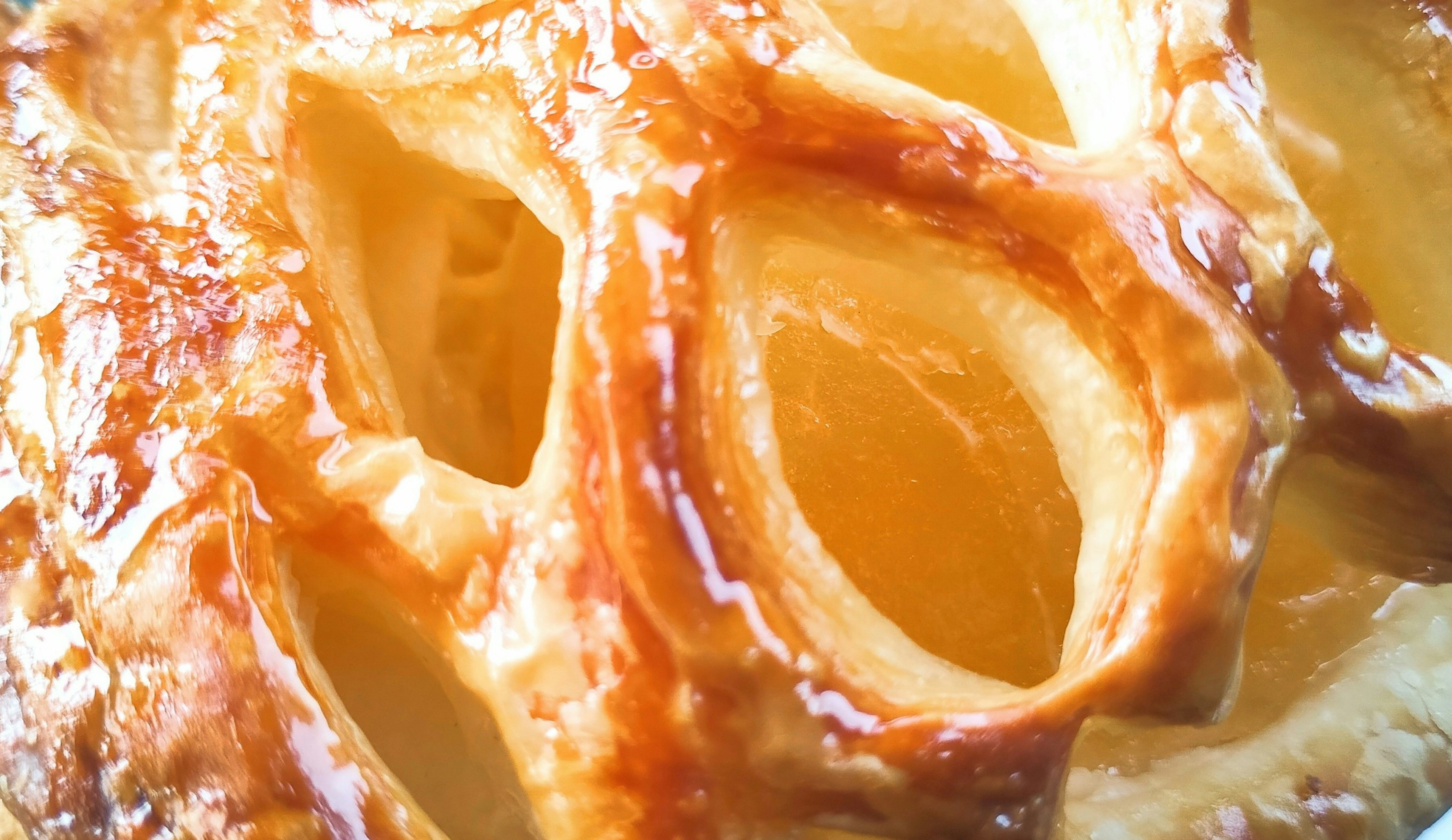 Close-up of a golden-brown apple pie crust with visible filling