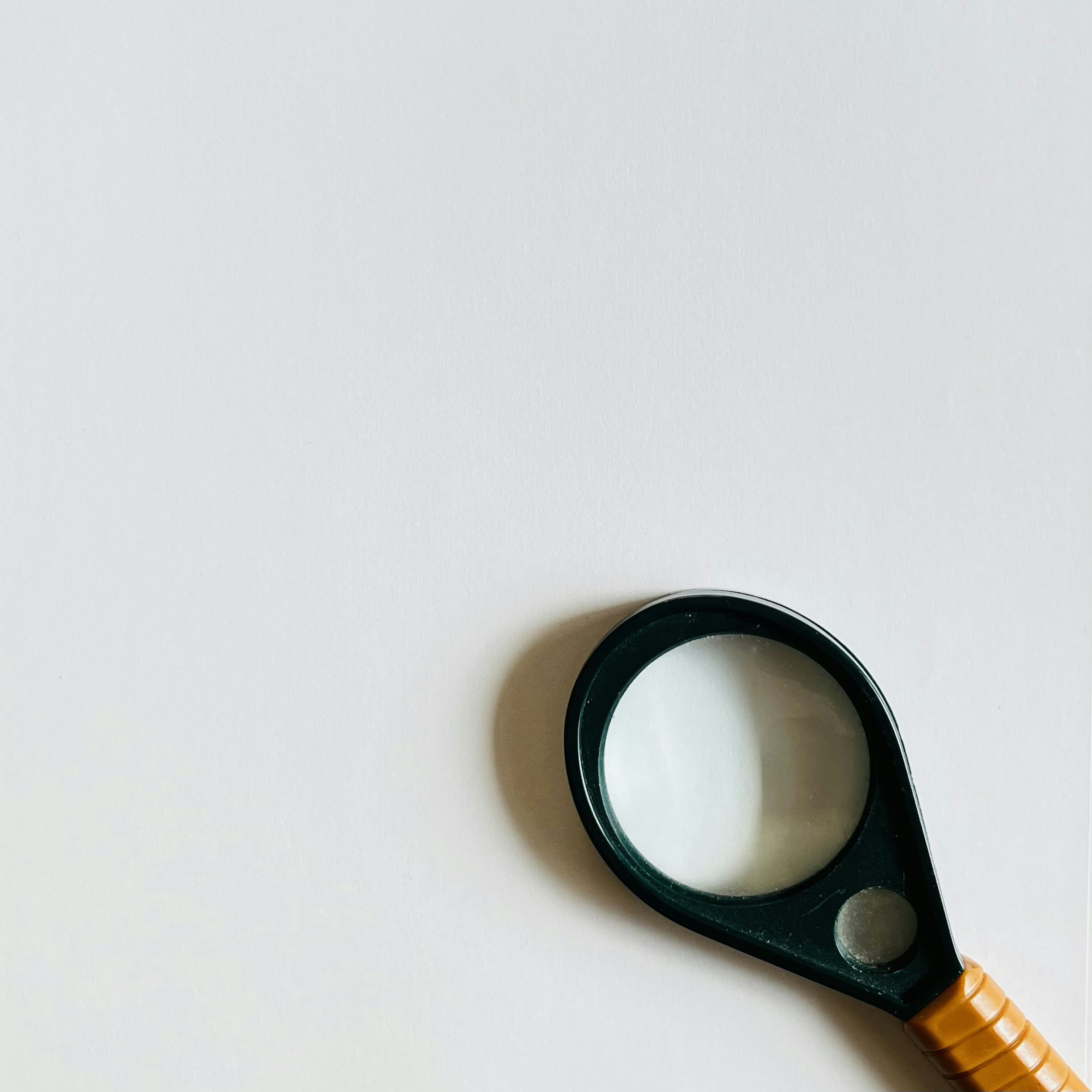 Simple image featuring a black magnifying glass on a white background