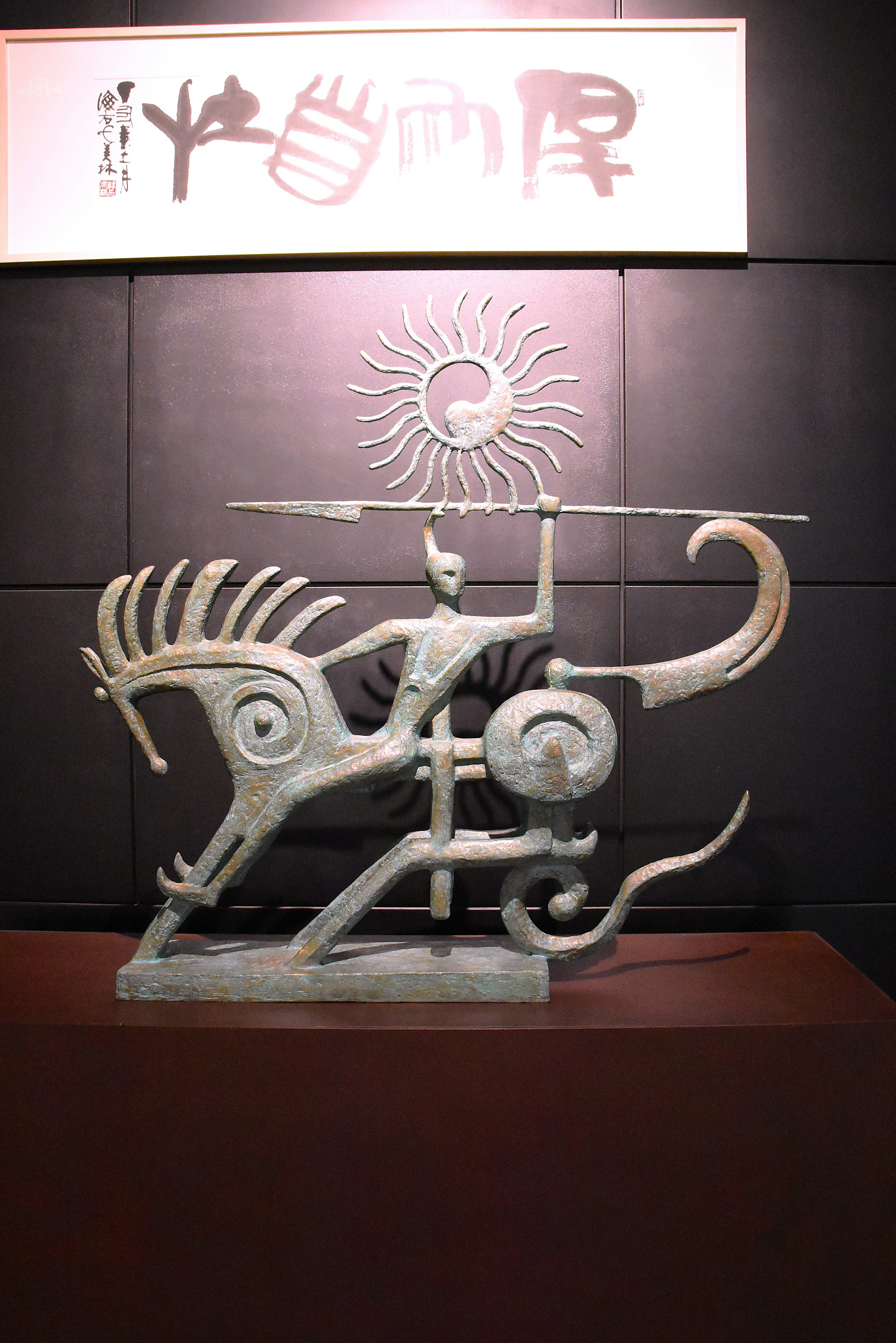 Scultura in metallo a forma di cavallo con dettagli intricati e simbolo del sole