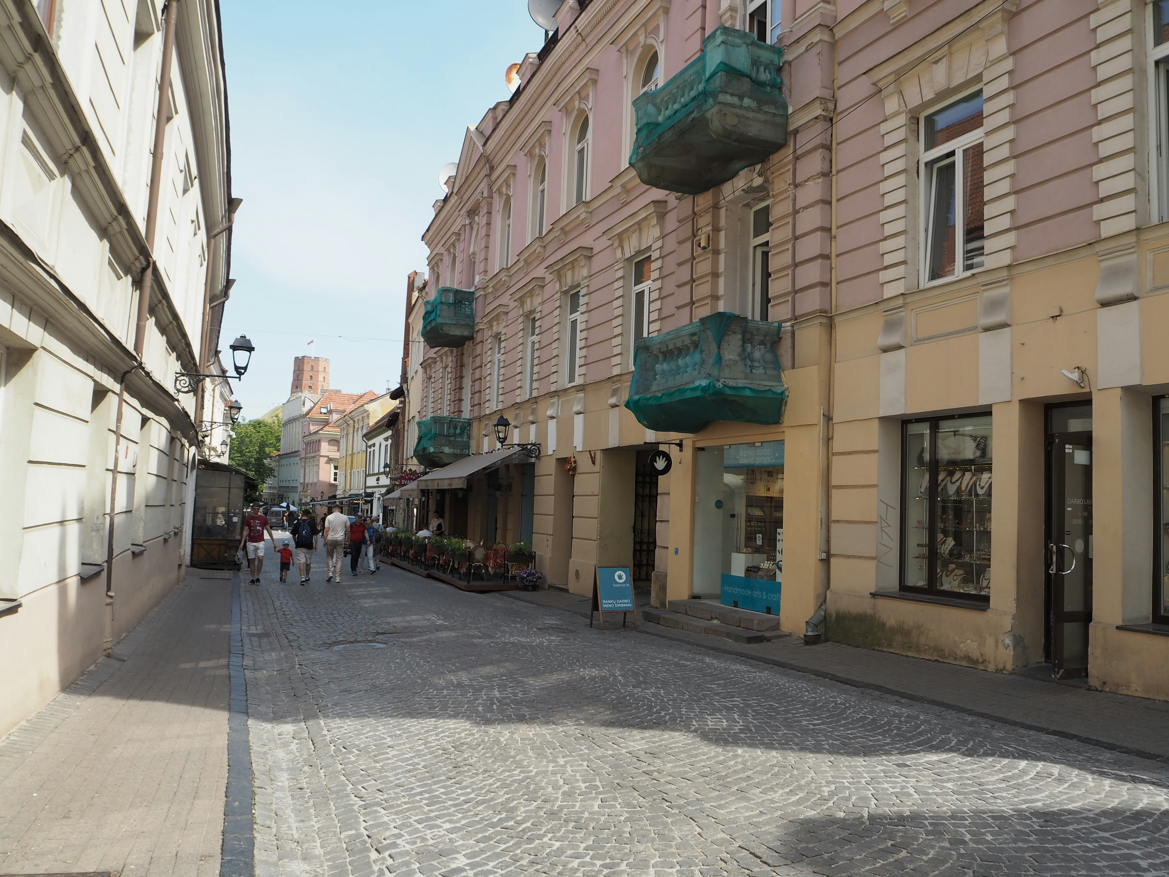 Strada acciottolata fiancheggiata da edifici colorati con balconi