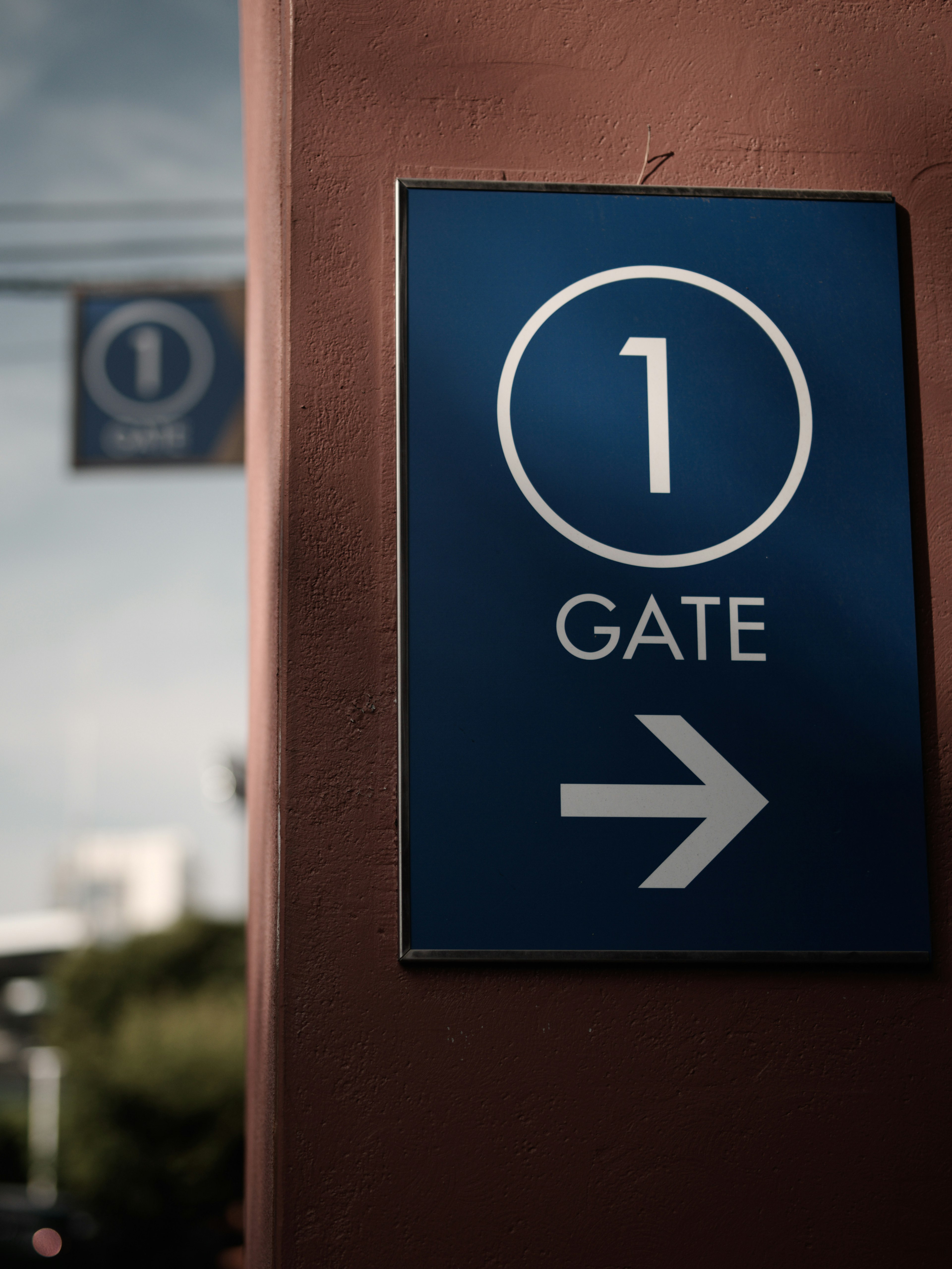 Blue sign indicating Gate 1 with an arrow pointing right