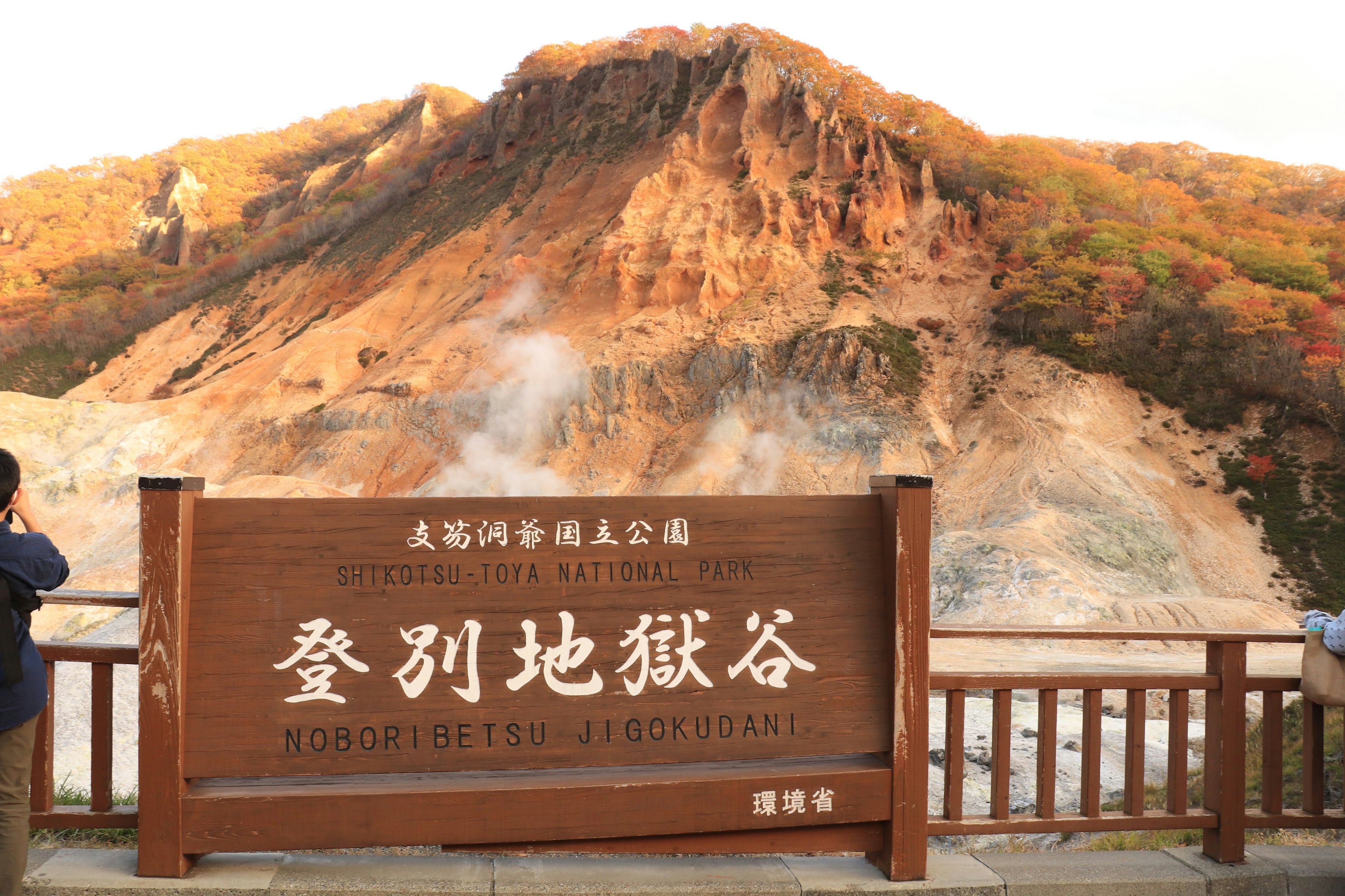 登別地獄谷の看板と背景の山々