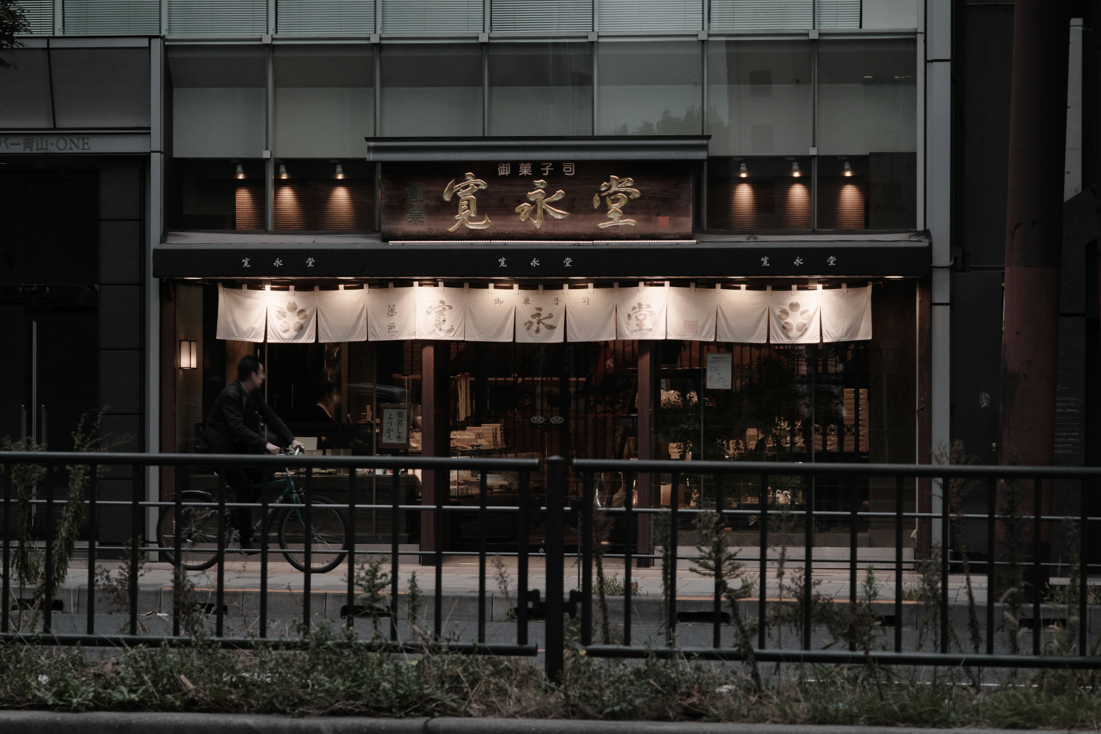 Entrance of a traditional Japanese shop with dark exterior and kanji sign