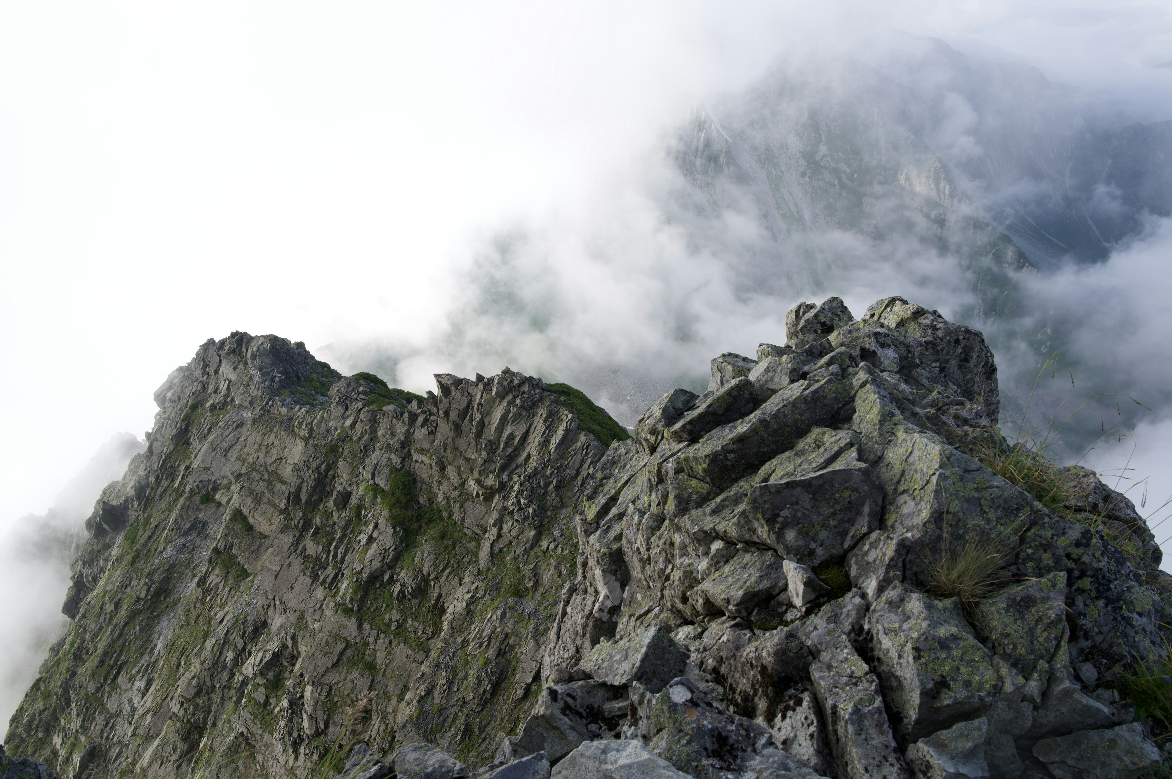 Vista dalla cima di una montagna rocciosa avvolta nelle nuvole