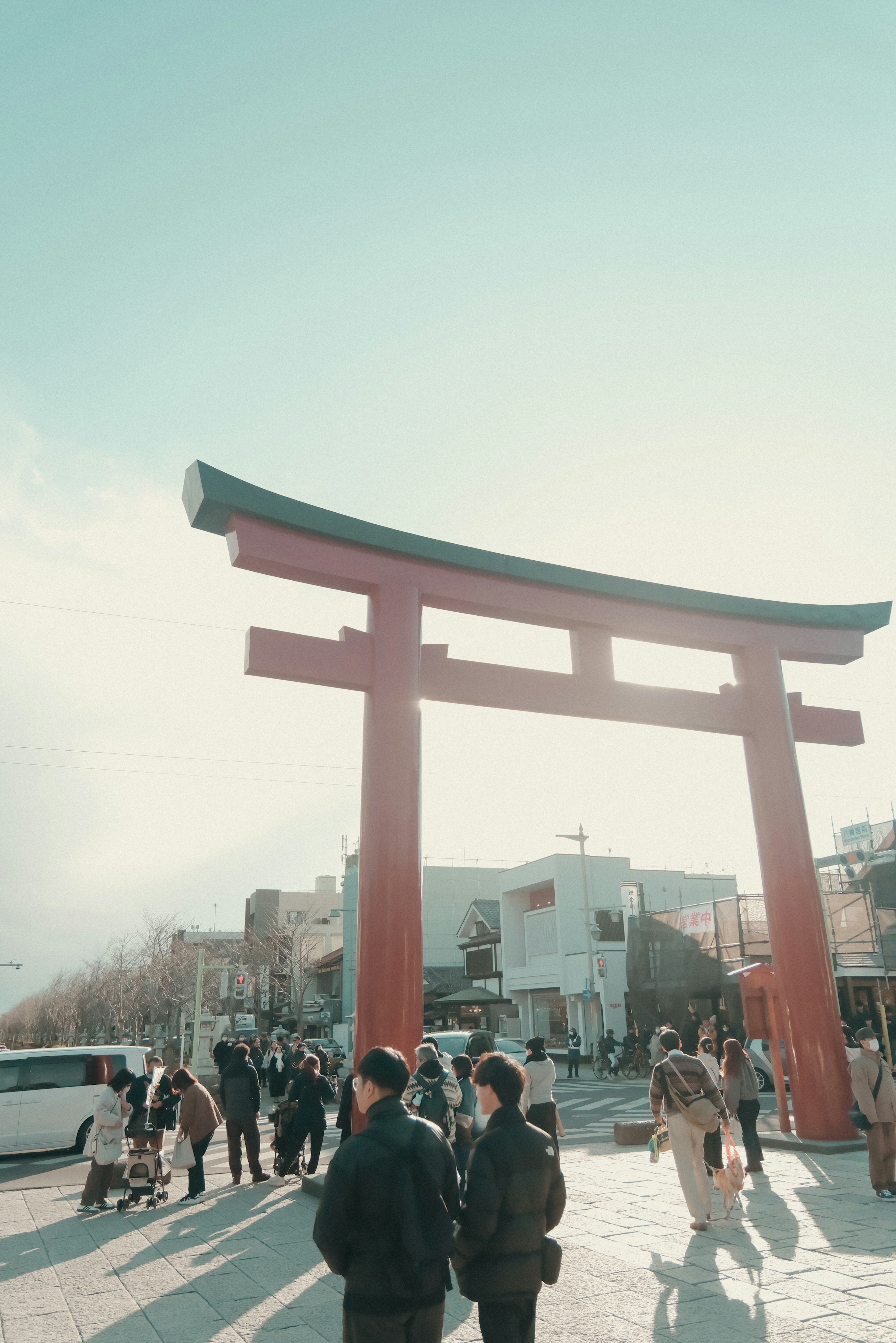 赤い鳥居の前に立つ観光客たちの風景