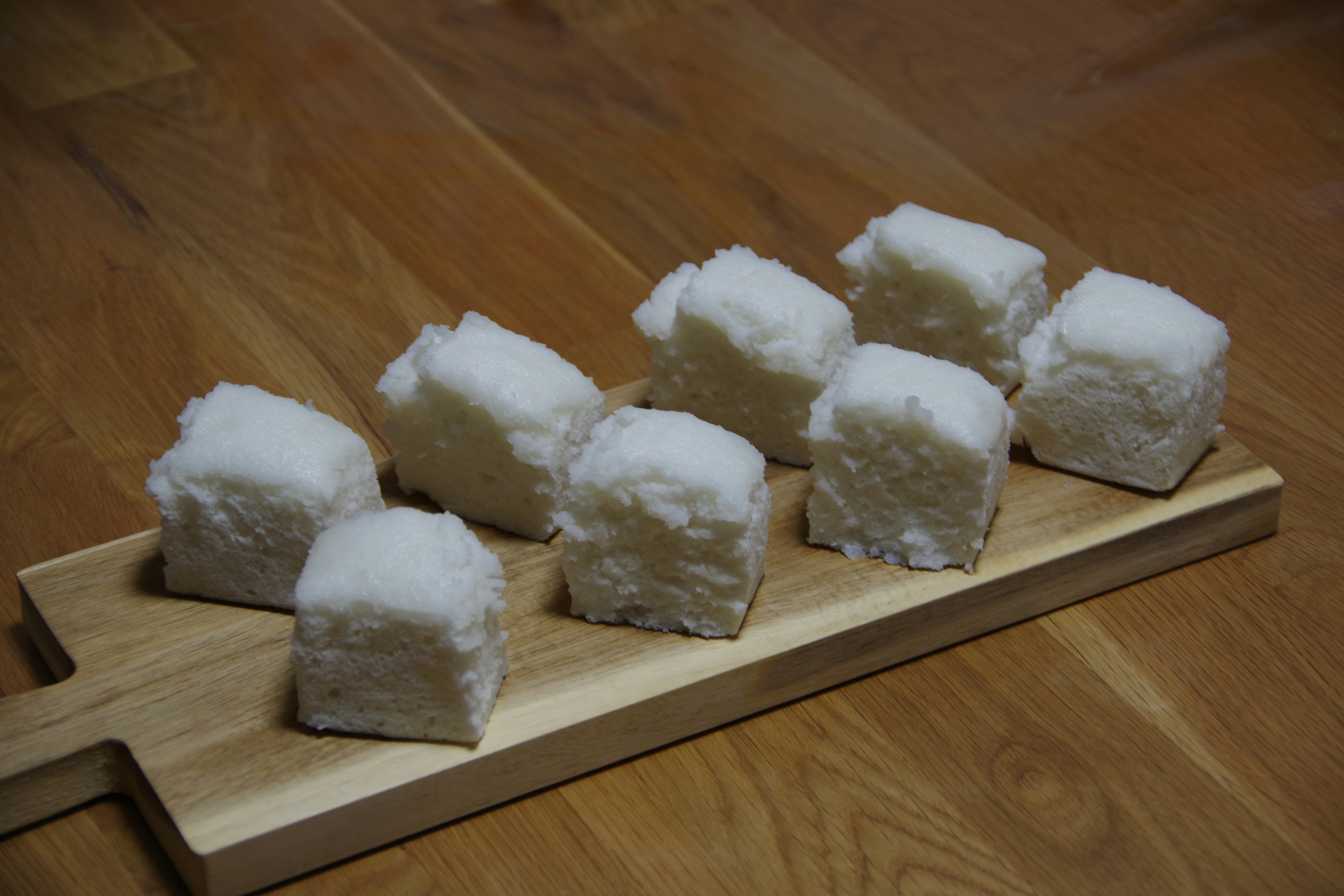 Pasteles de arroz blancos dispuestos en una tabla de madera