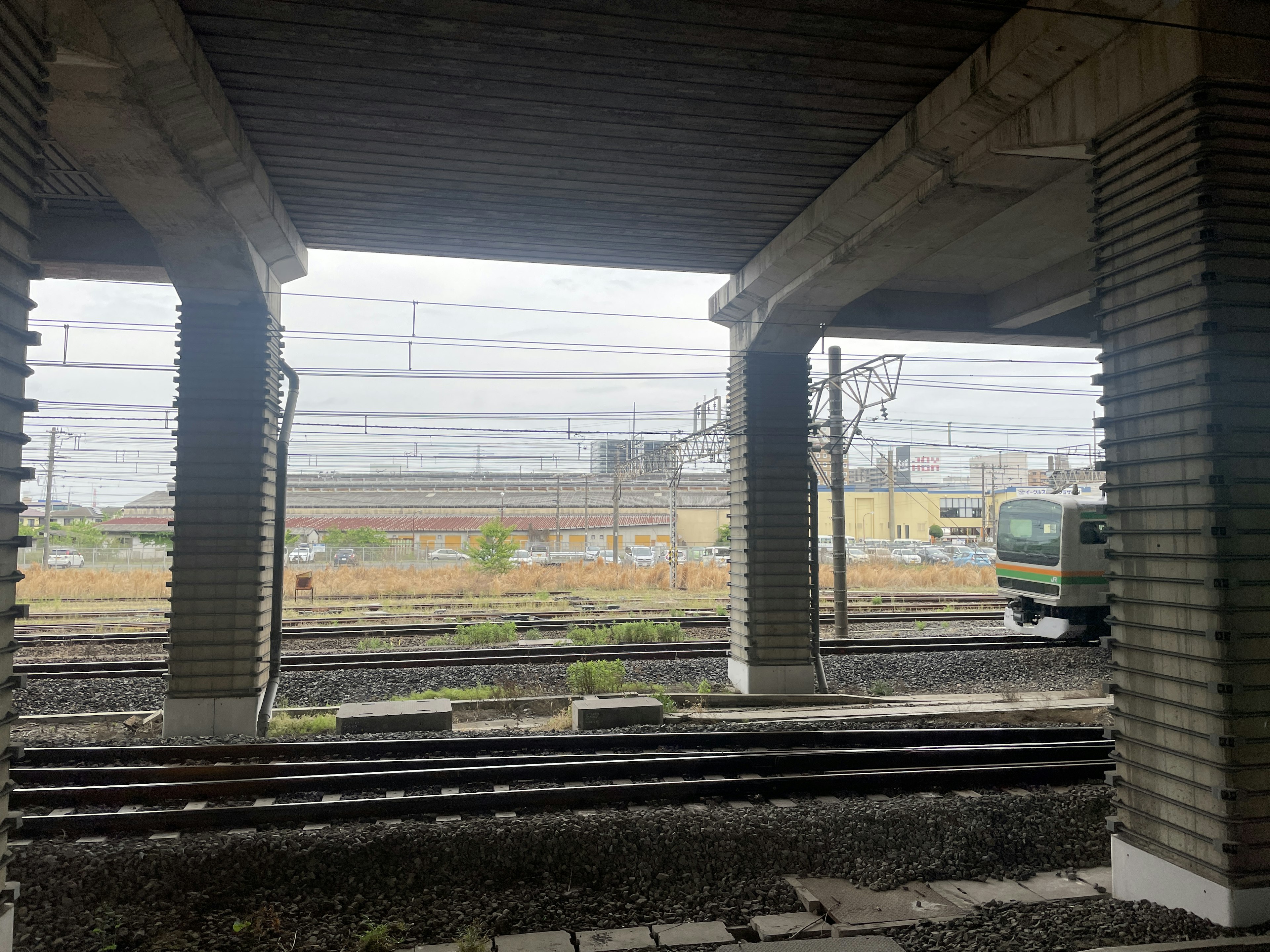 Vista dei binari e di un treno da sotto un ponte