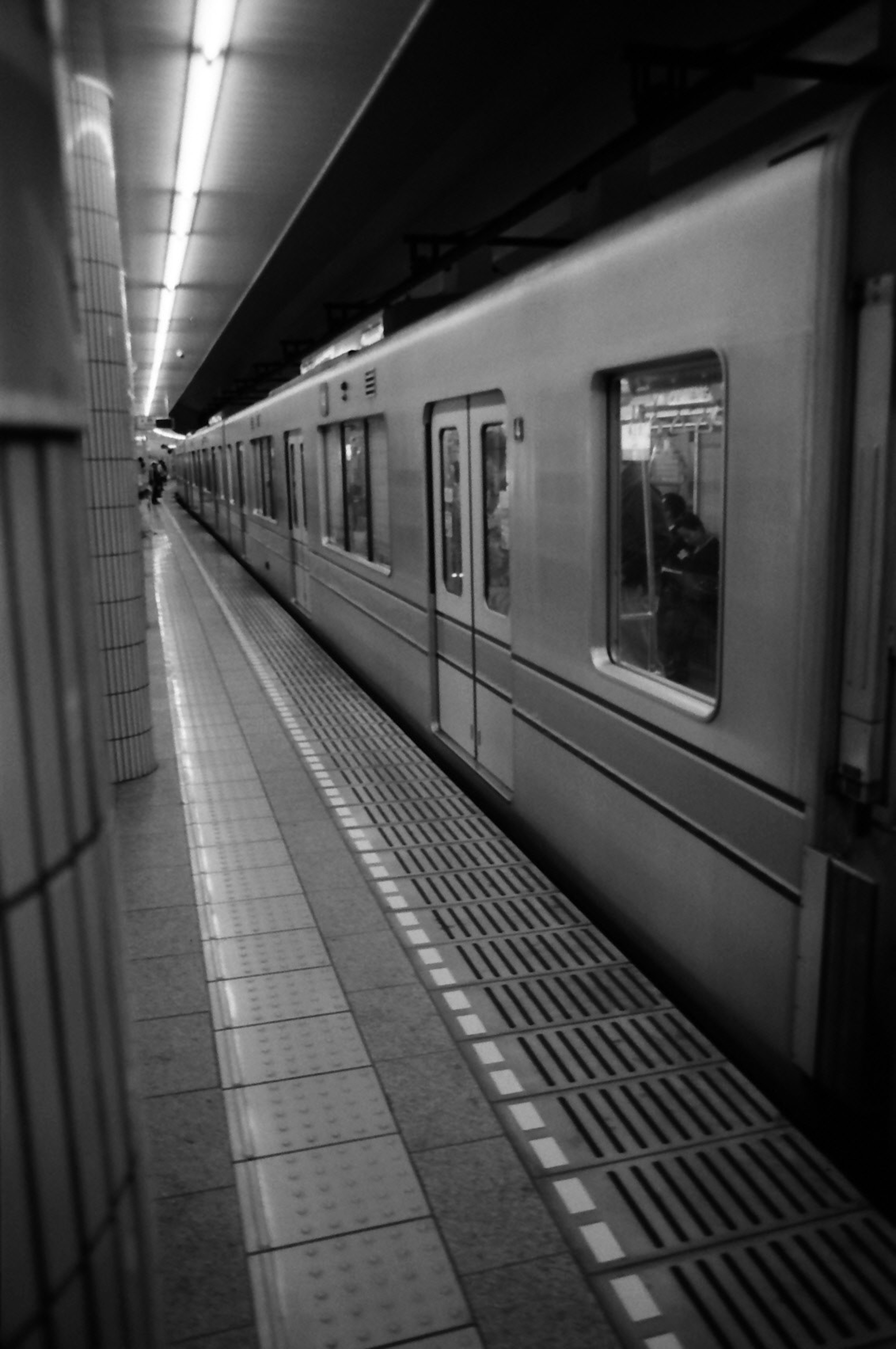 Imagen en blanco y negro de una plataforma de metro con un tren