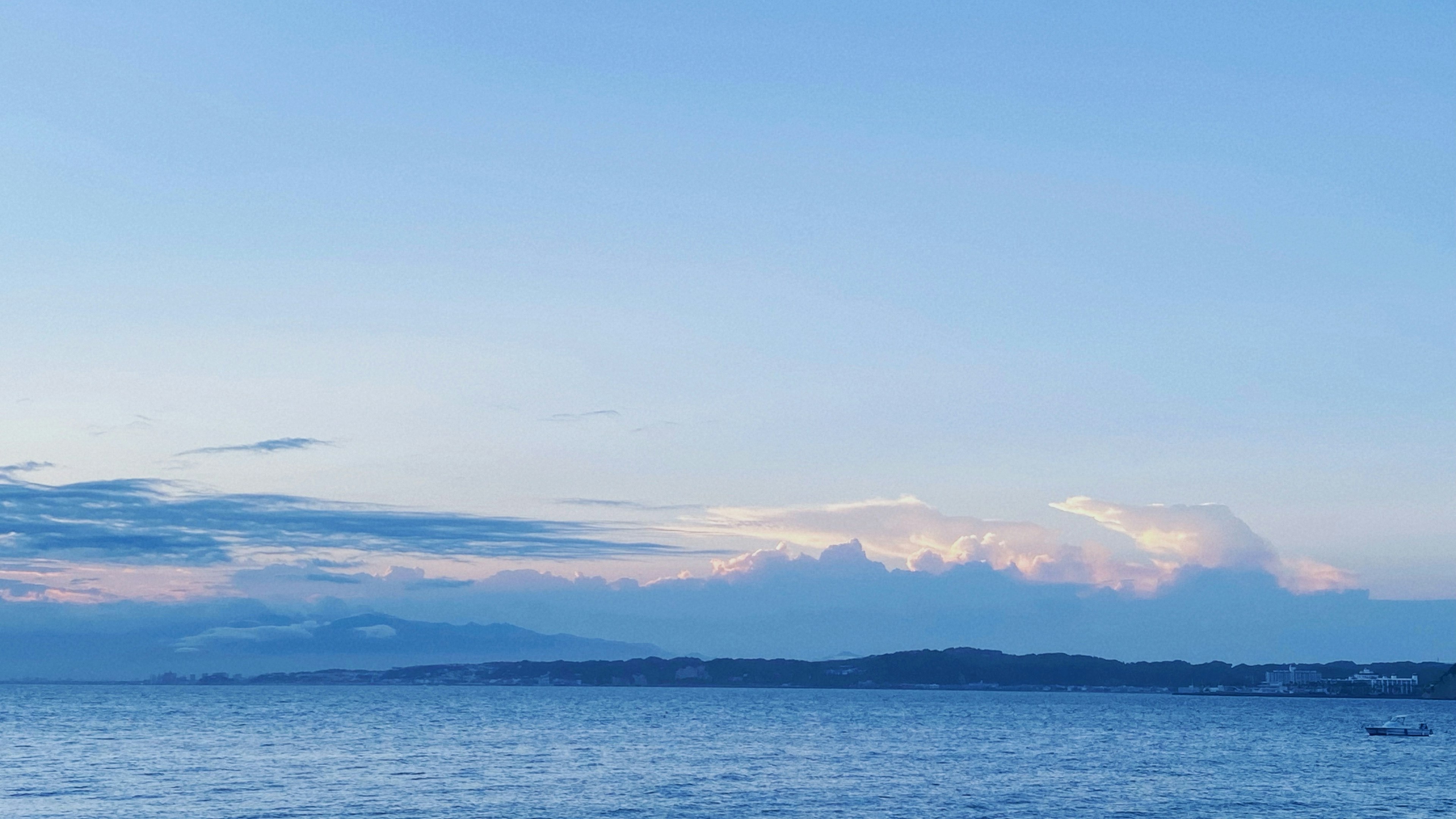 Pemandangan laut tenang dengan langit biru dan awan