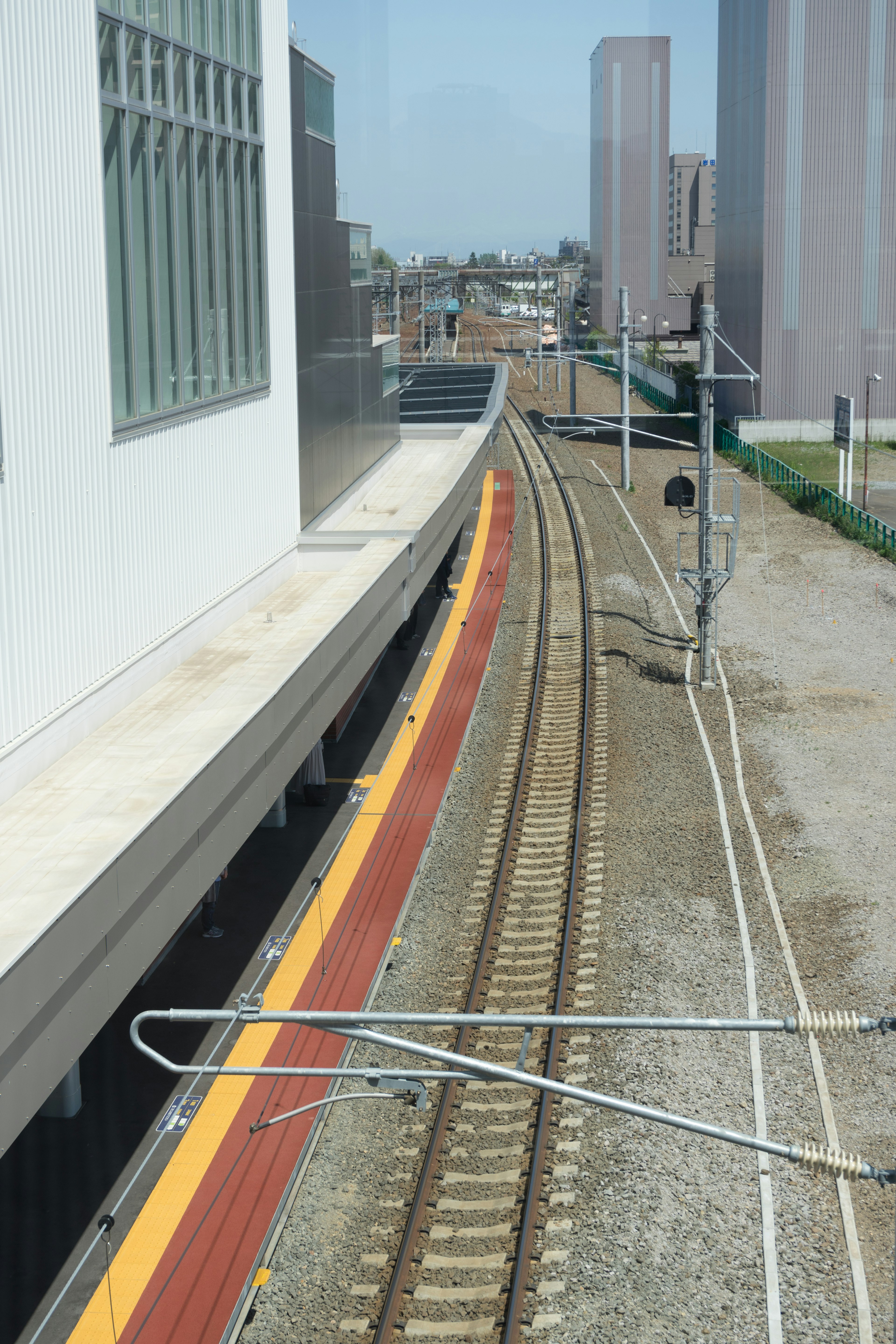 Curved railway tracks and platform in an urban setting