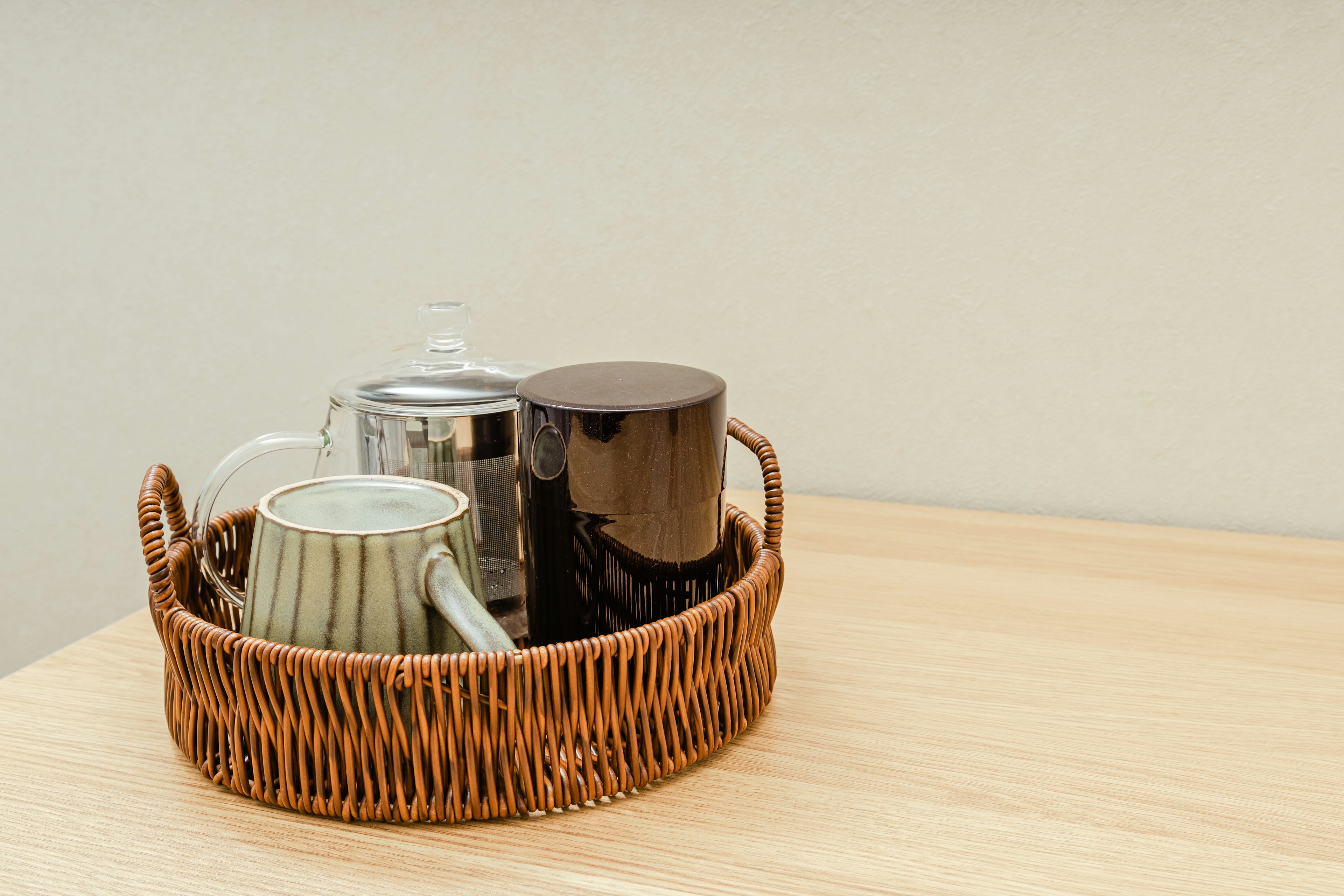 Set of cups and teapot on a wicker tray