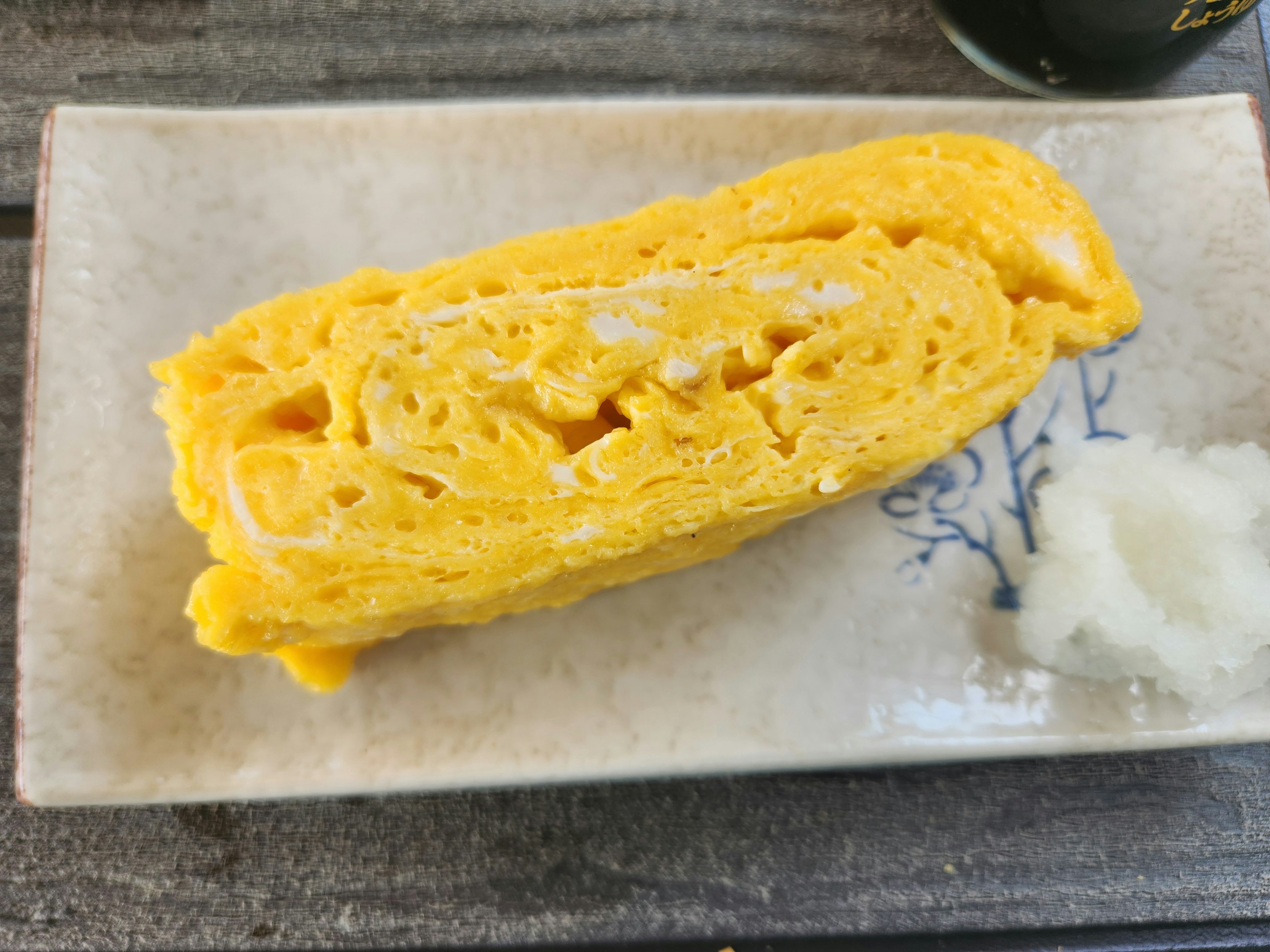 Fluffige japanische Omelette auf einem weißen Teller serviert