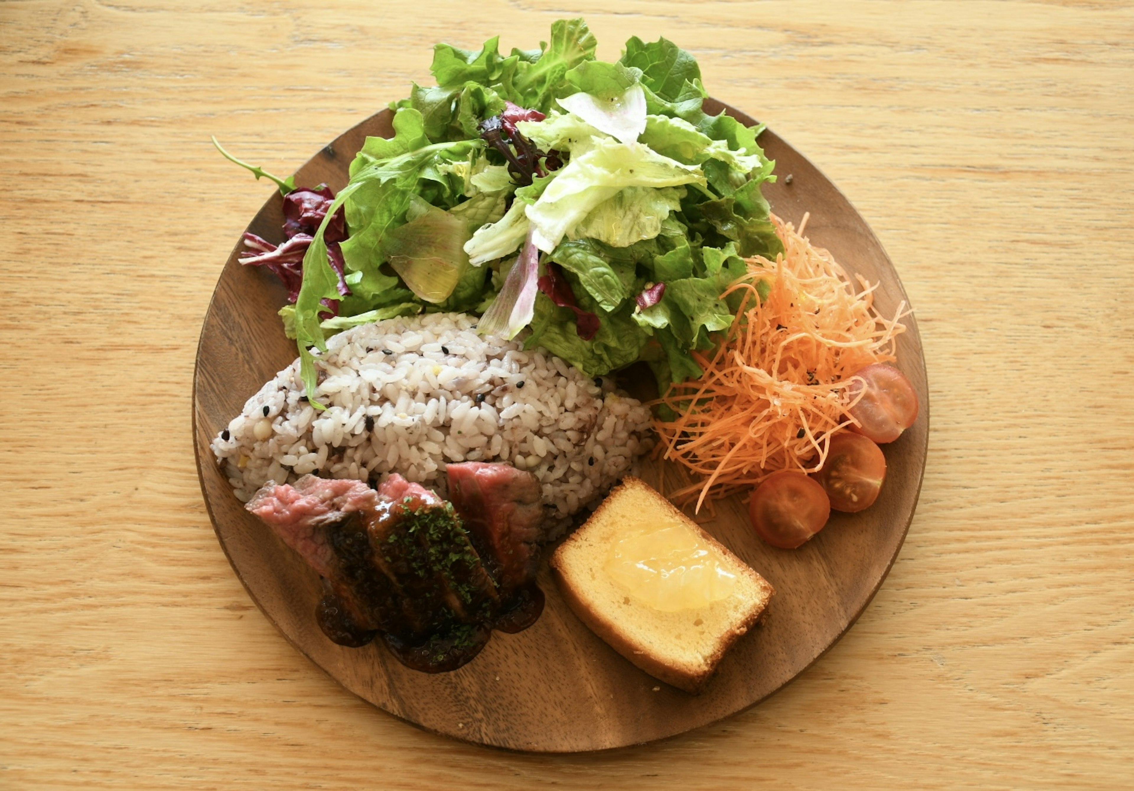 Sebuah piring dengan salad berwarna-warni, nasi, dan berbagai lauk