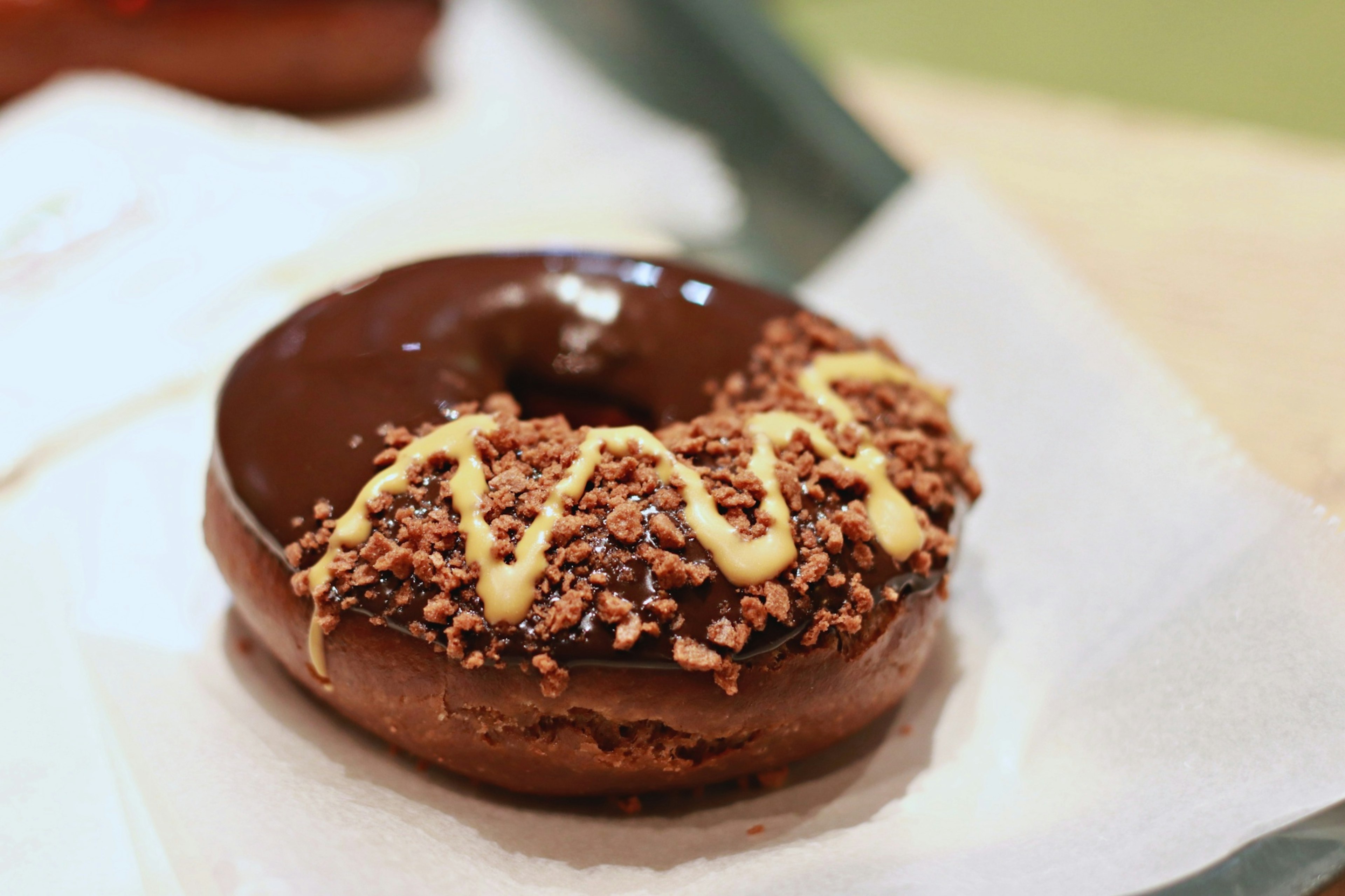 Schokoladenglasierte Donut mit Nüssen und Sahne