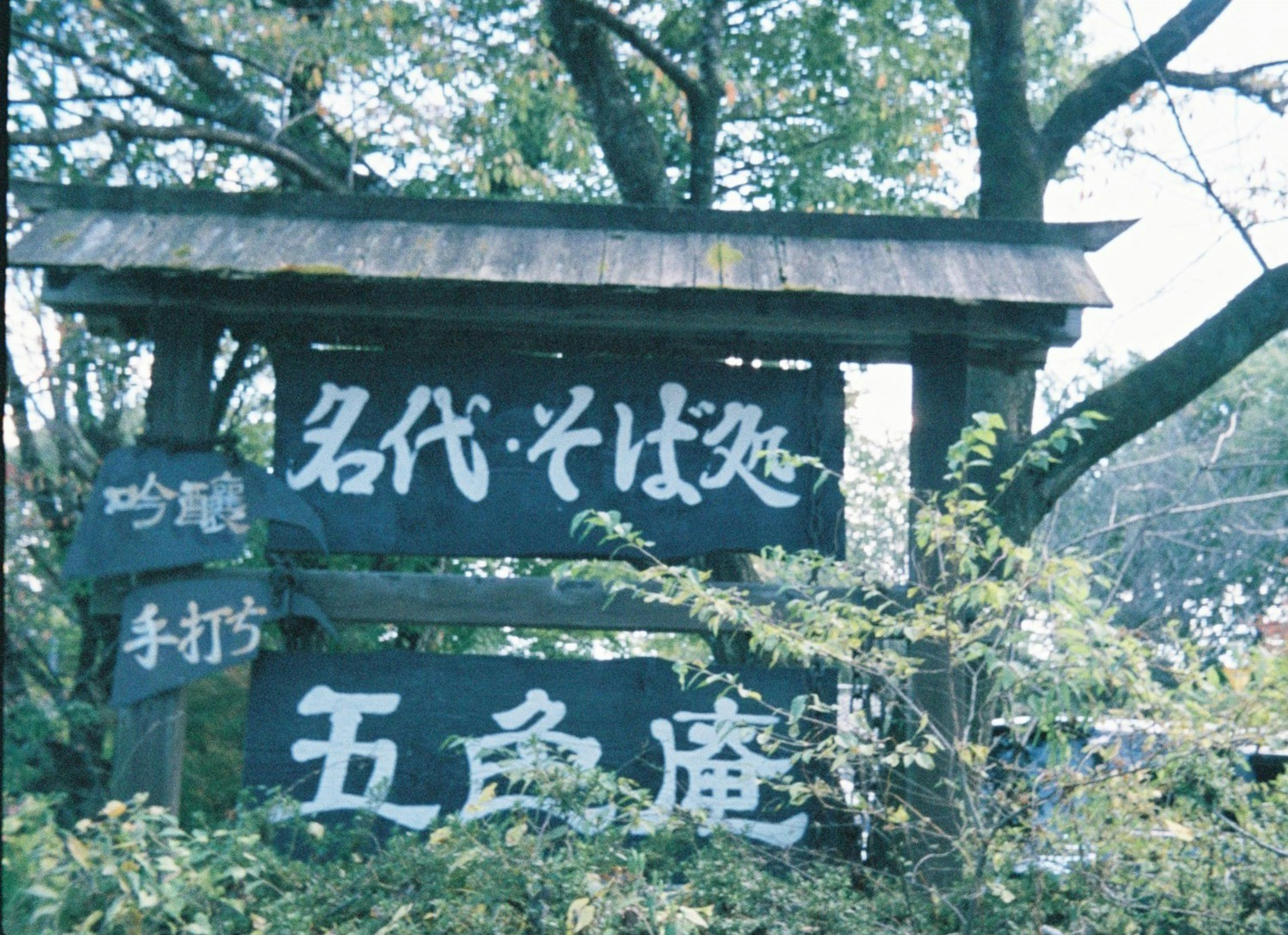 古い木製の看板に手書きの文字が書かれた風景