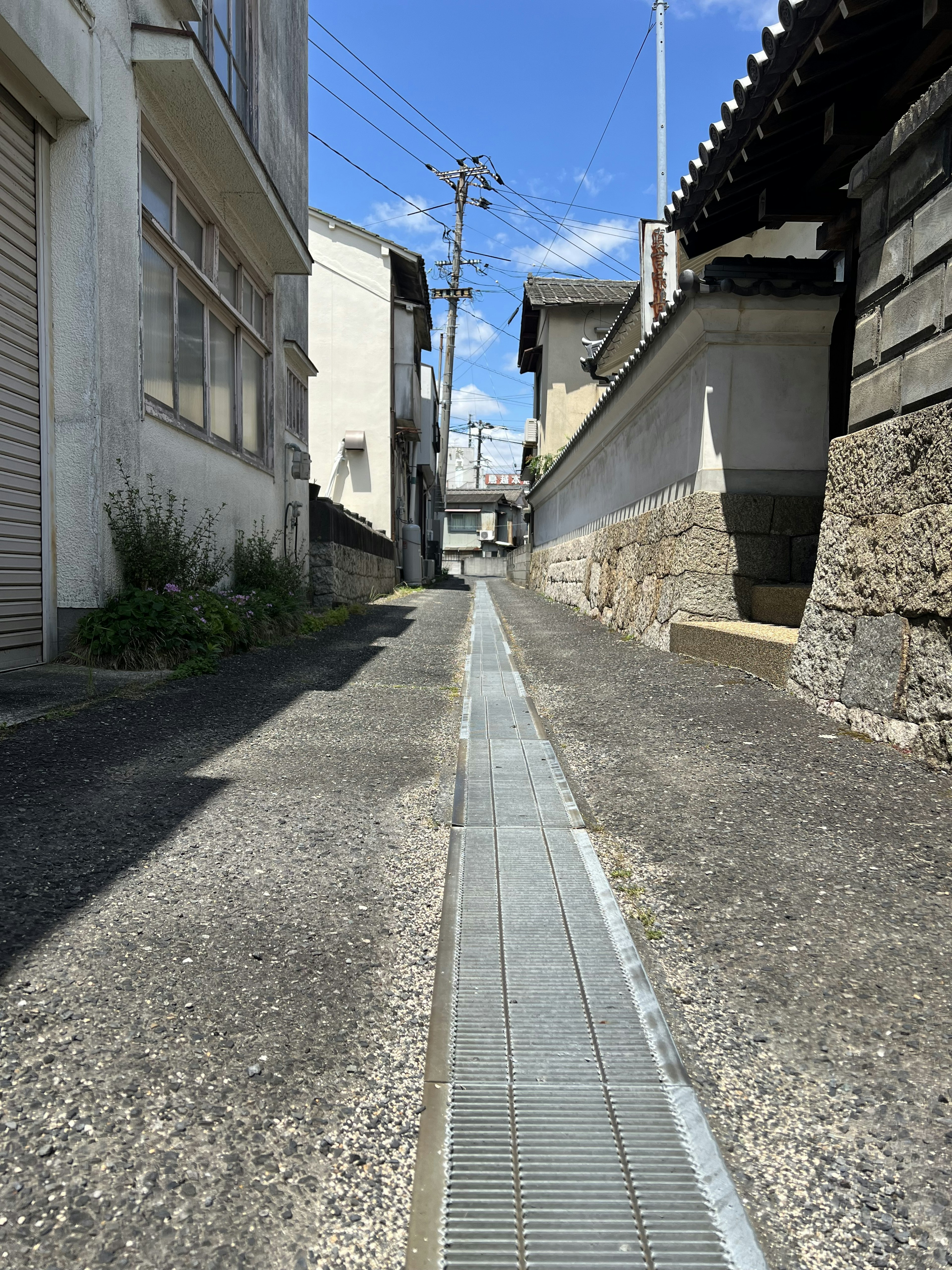 Allée étroite avec un chemin en béton et des bâtiments environnants