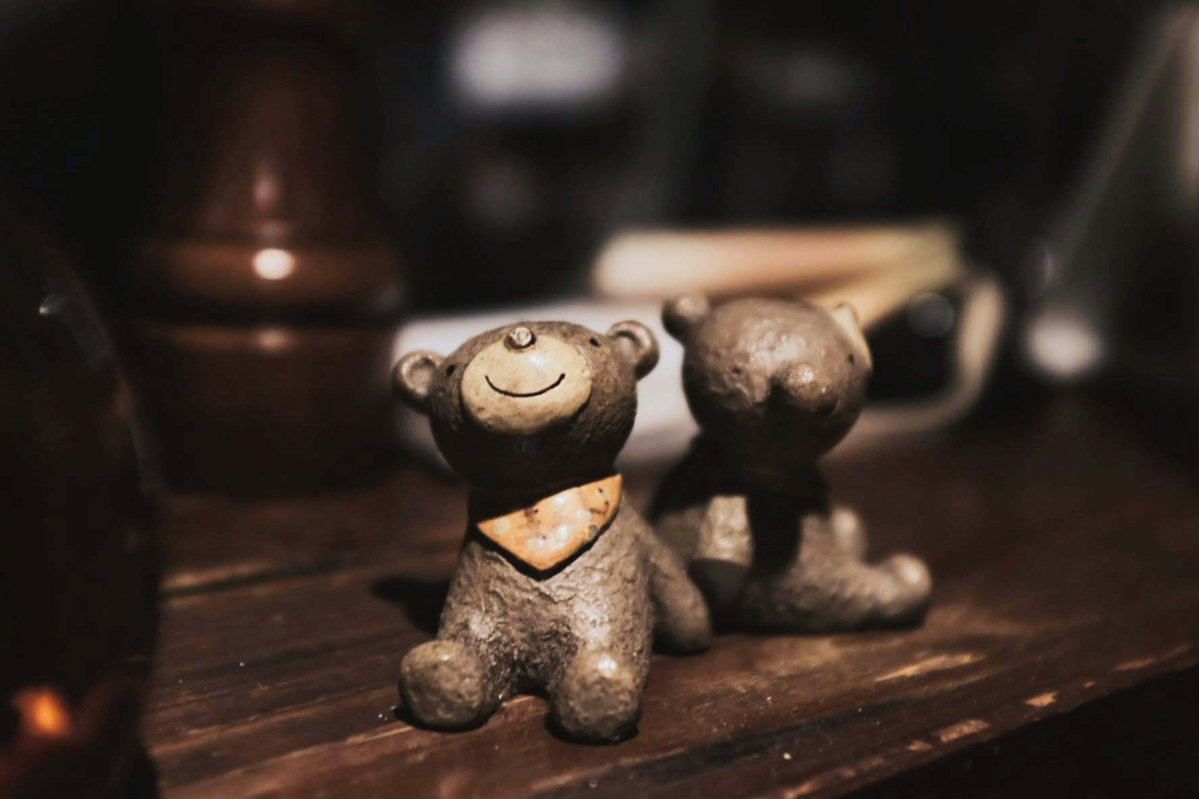 Two small bear figurines sitting on a wooden table