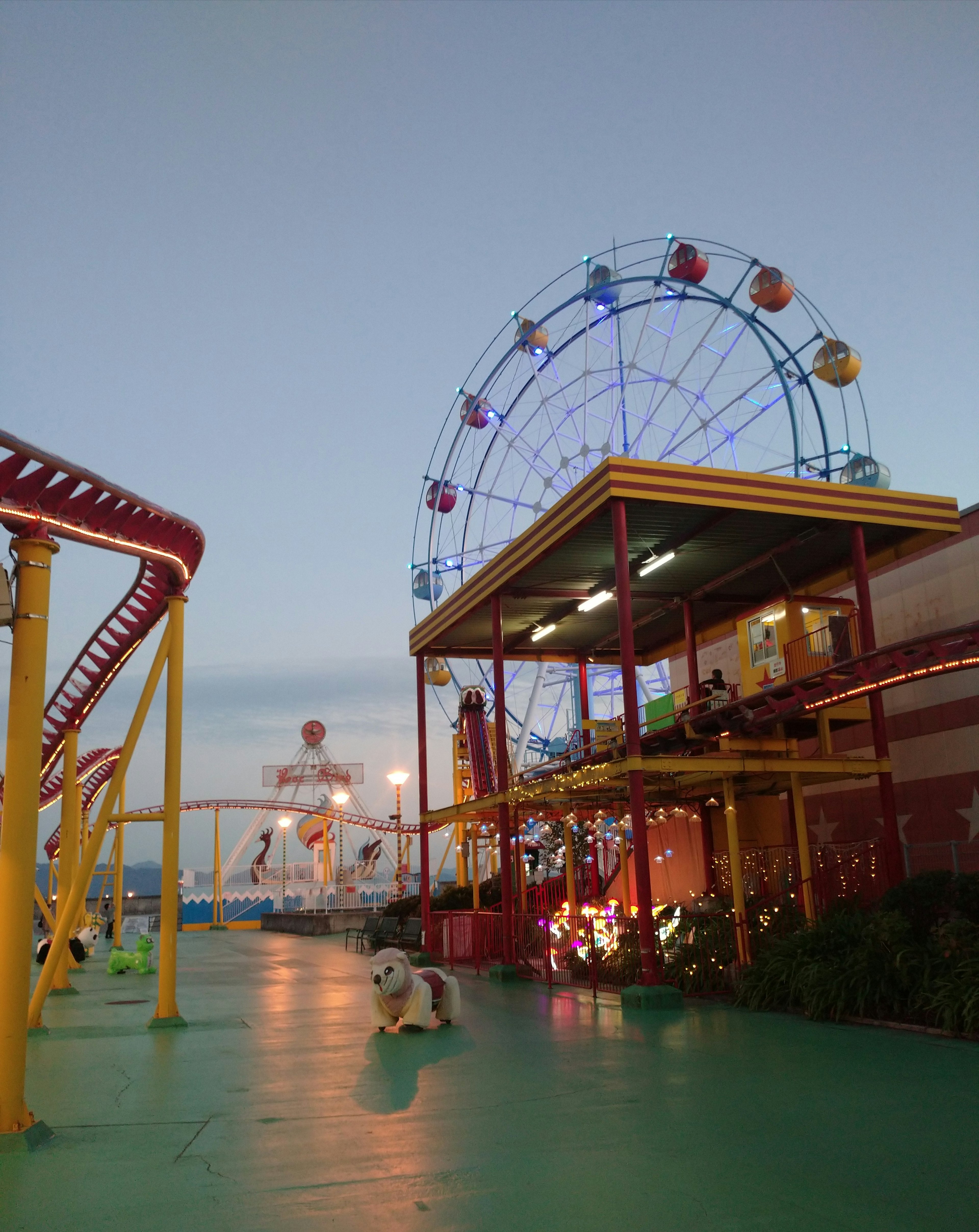 Amusement park scene featuring a colorful Ferris wheel and attractions