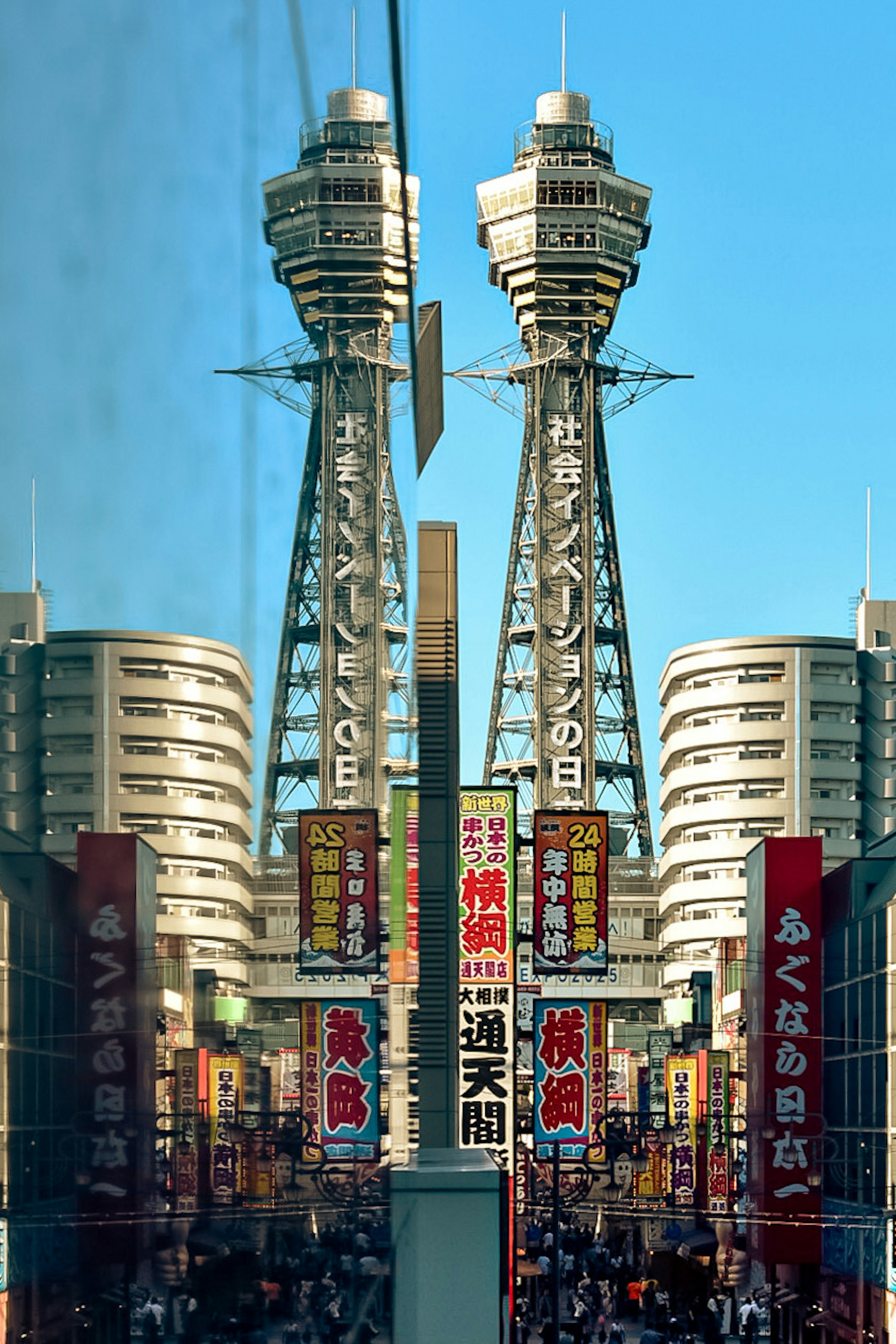 La torre Tsutenkaku de Osaka reflejada en una escena urbana bulliciosa con letreros coloridos