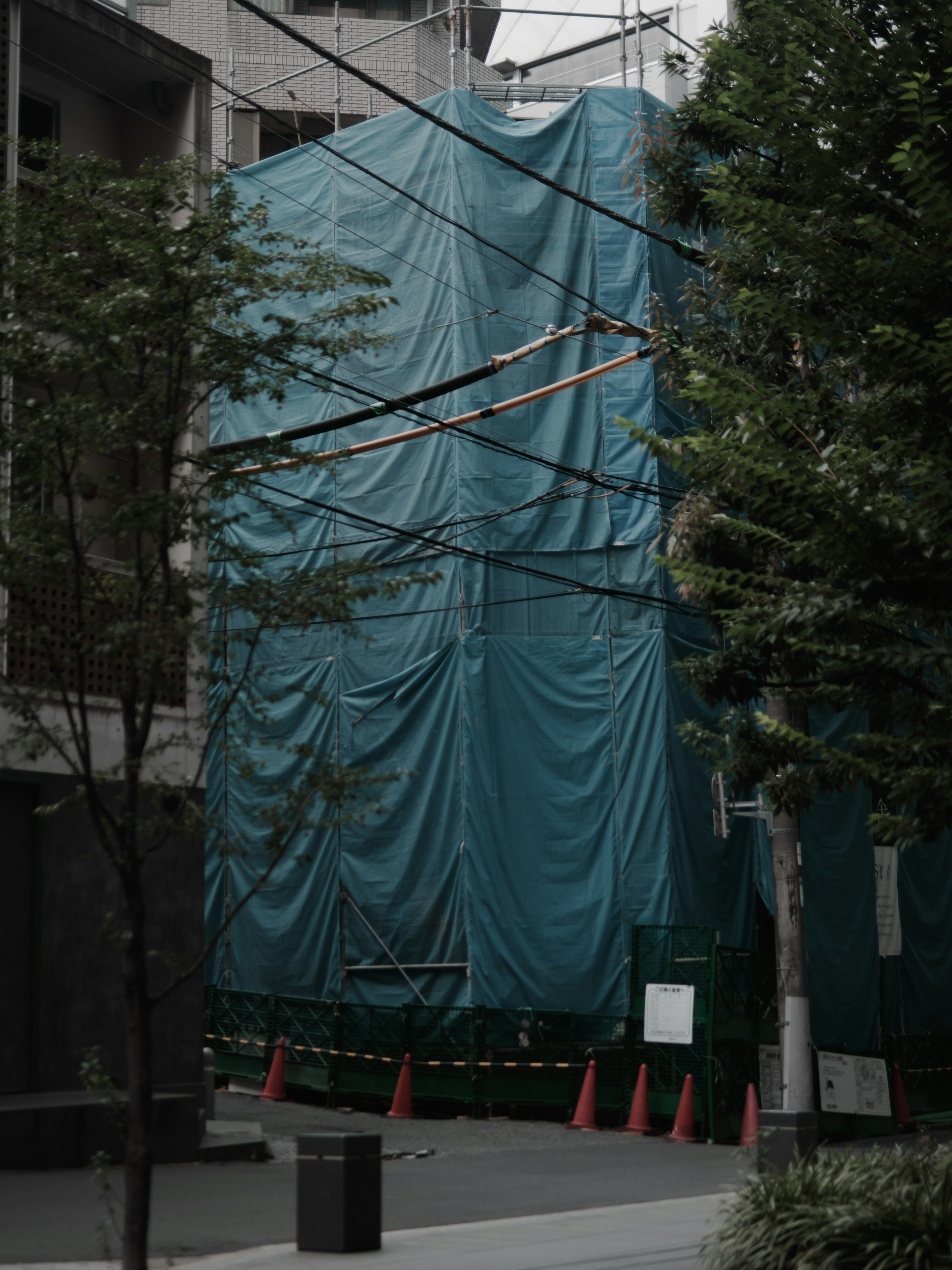 Site de construction recouvert d'une bâche bleue dans un cadre urbain