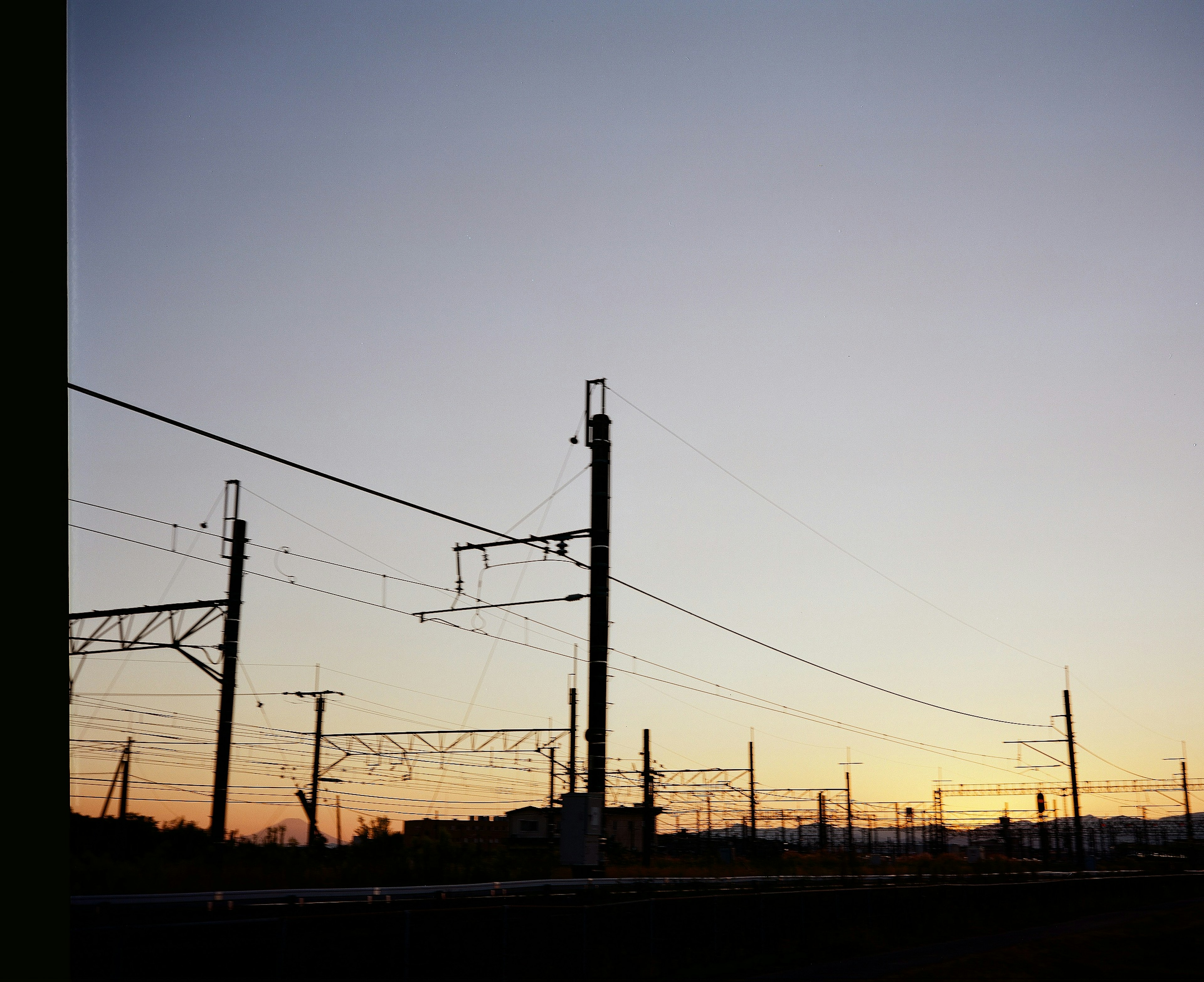 Silueta de postes de ferrocarril contra un cielo al atardecer