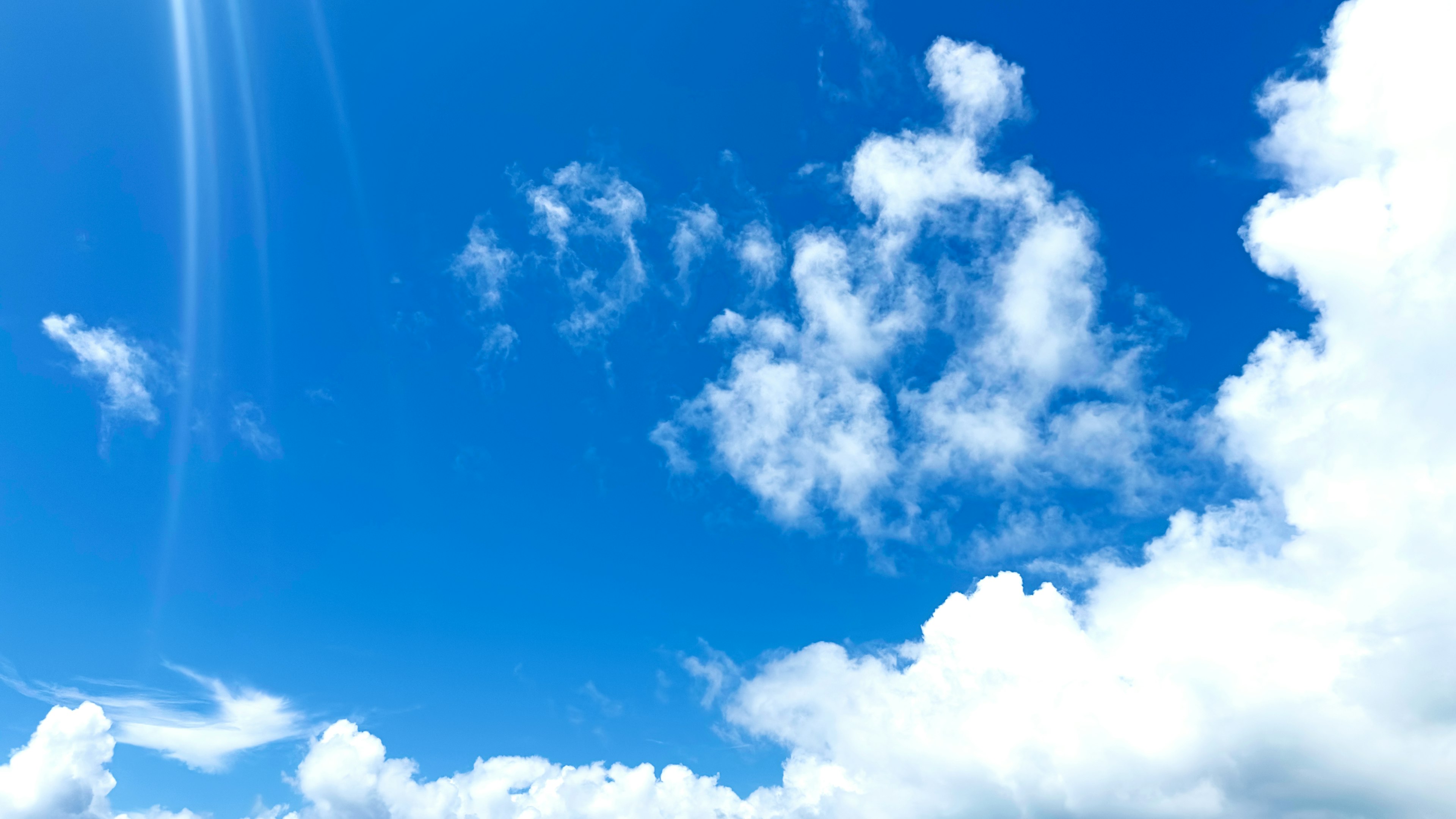 Ein klarer blauer Himmel mit fluffigen weißen Wolken