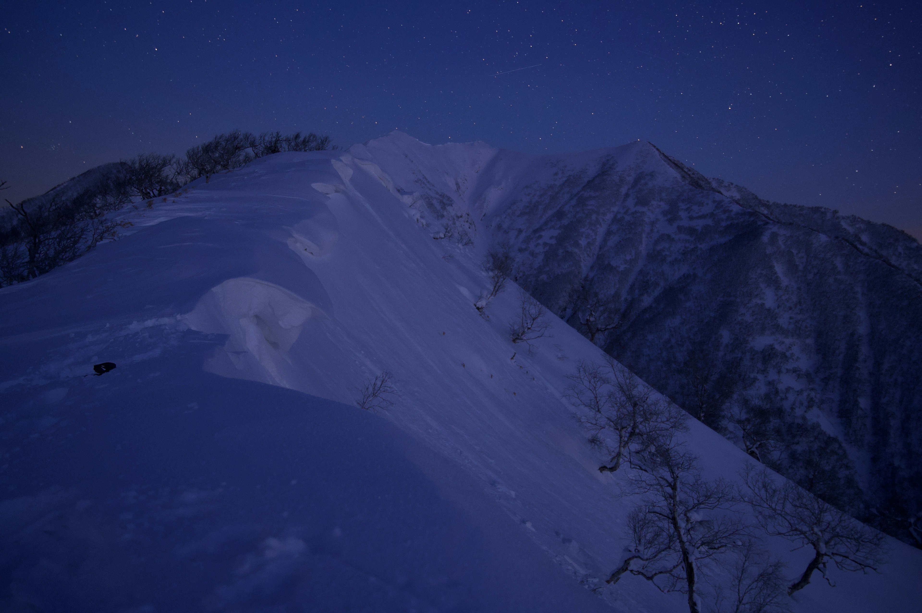 夜の雪山の風景と星空が広がる