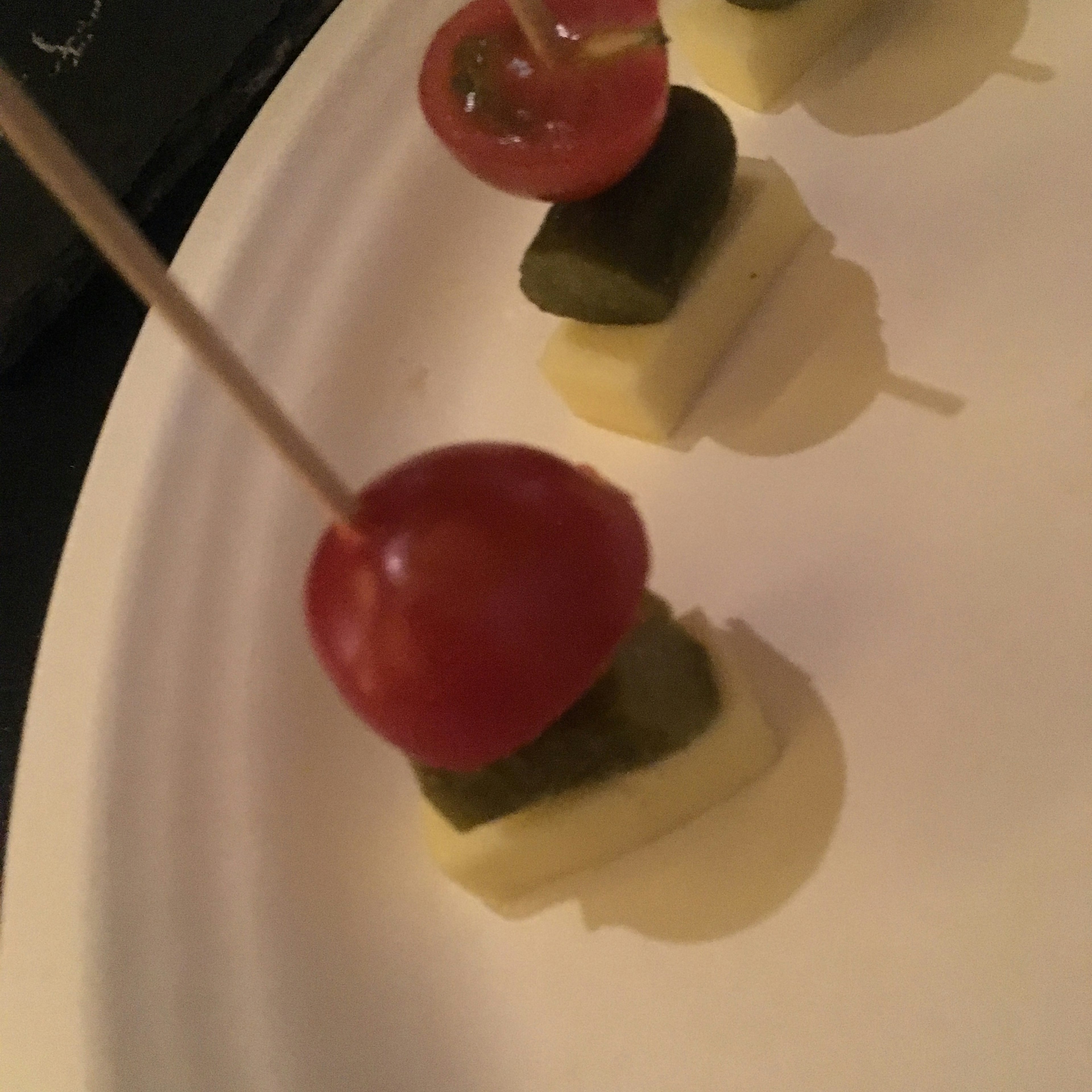 Red tomato green pickle and white cheese skewered snack