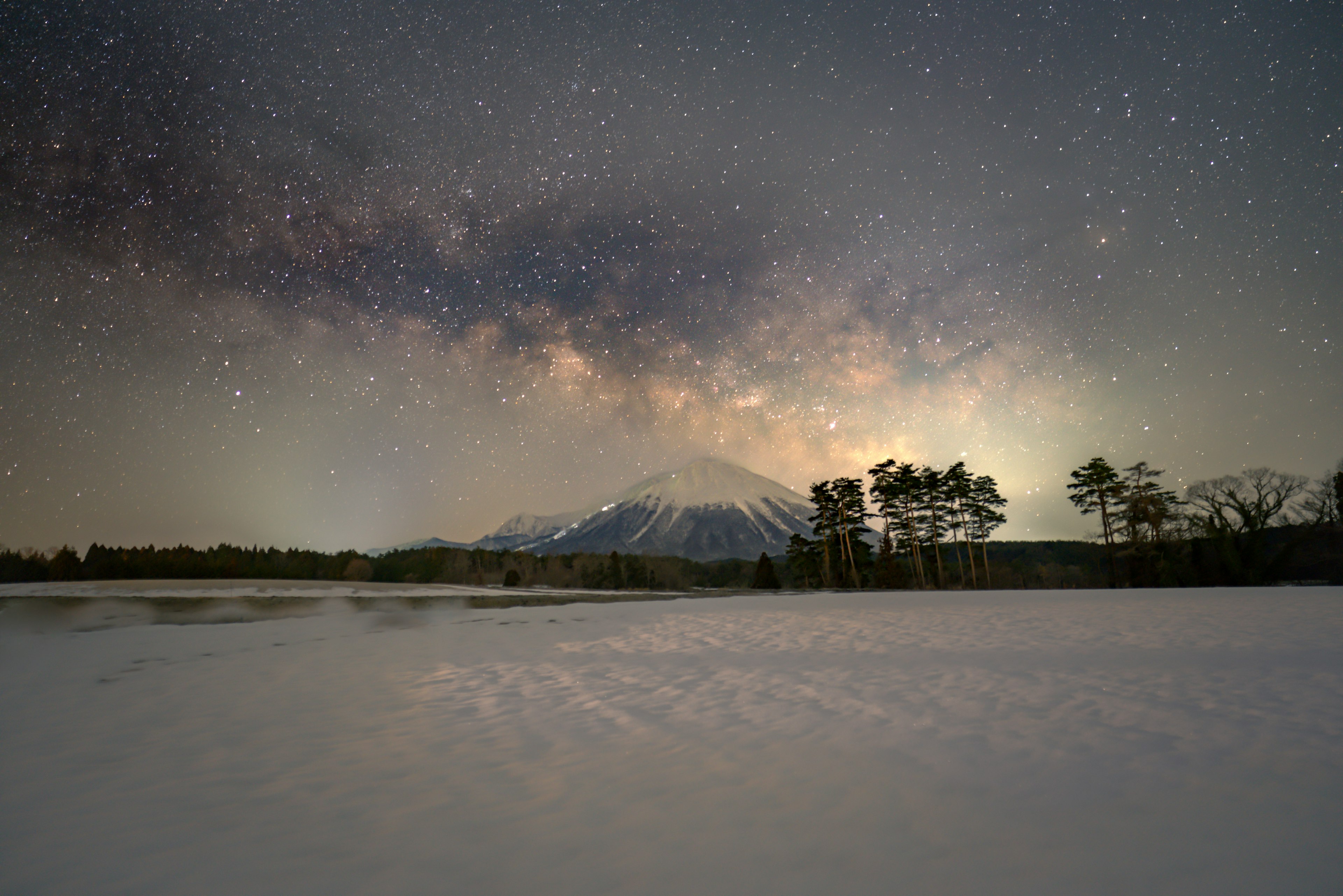 Schneebedeckte Landschaft mit einem Berg unter einem sternklaren Himmel