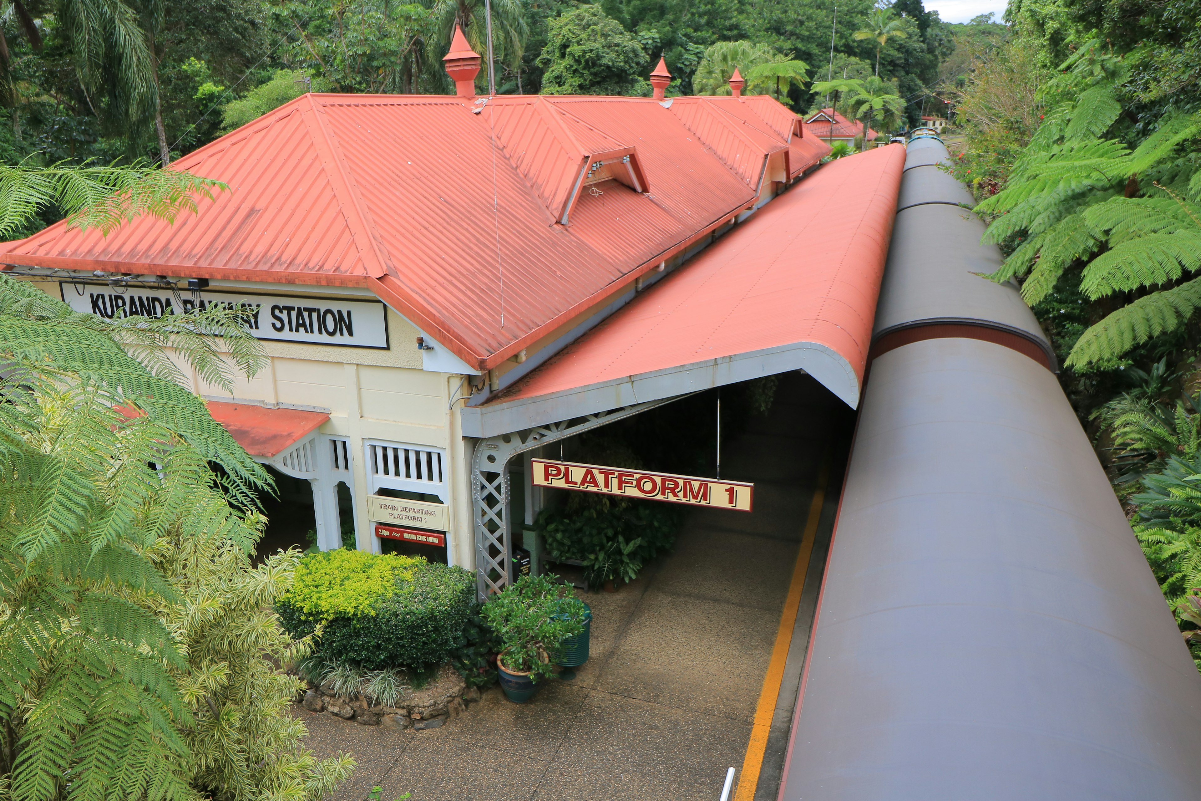 Bahnhof Katoomba mit rotem Dach umgeben von üppigem Grün und einem überdachten Bahnsteig