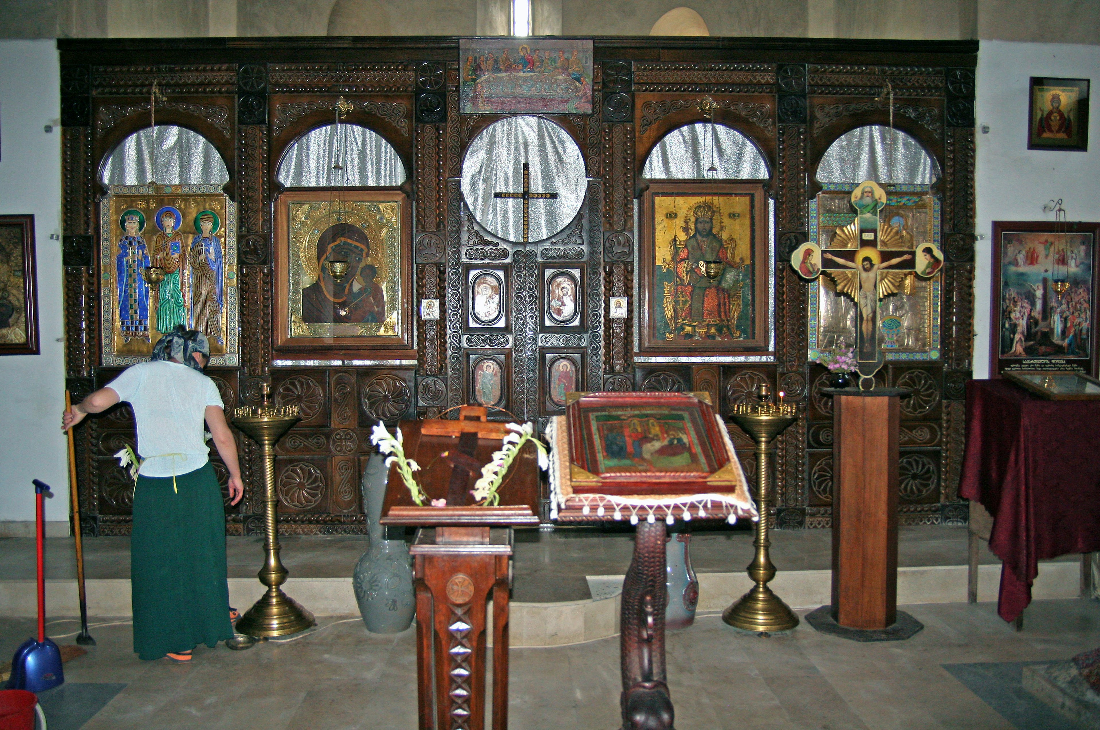 Interior of a church featuring a wooden altar and religious paintings on the wall