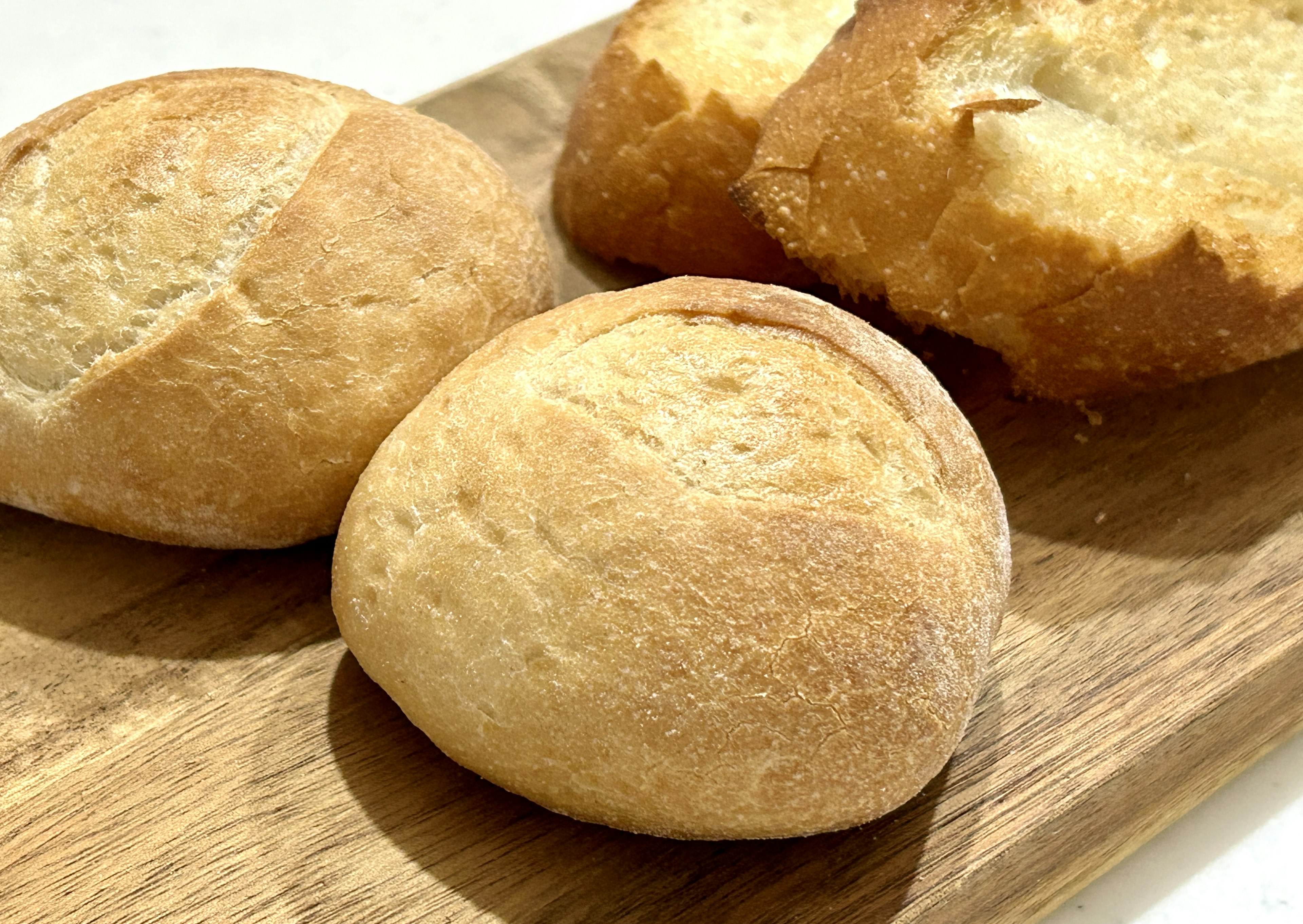 Bread rolls and sliced bread arranged on a wooden board