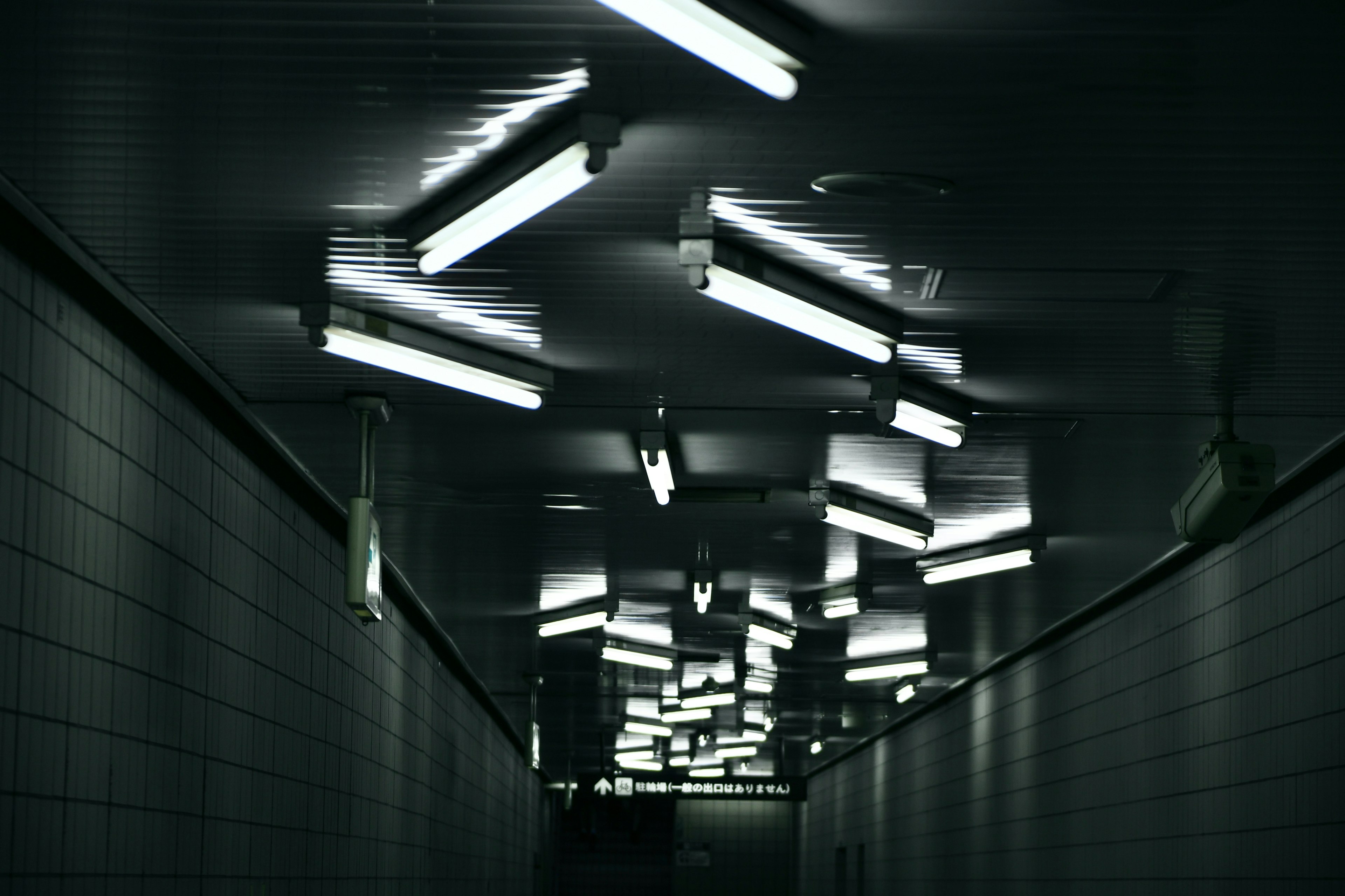 Dimly lit hallway with irregular fluorescent lights