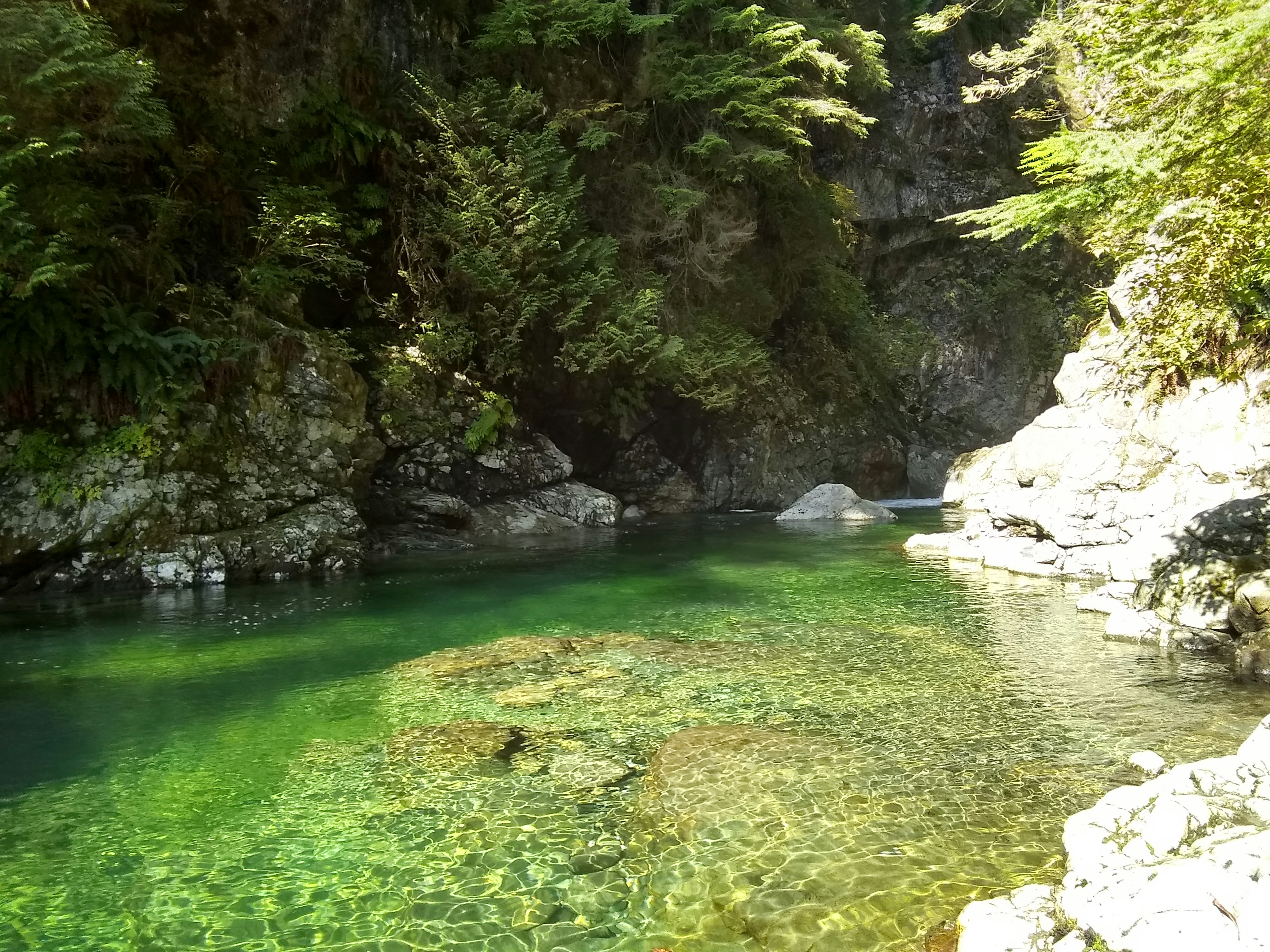 宁静的山谷场景，绿色水域被岩石环绕