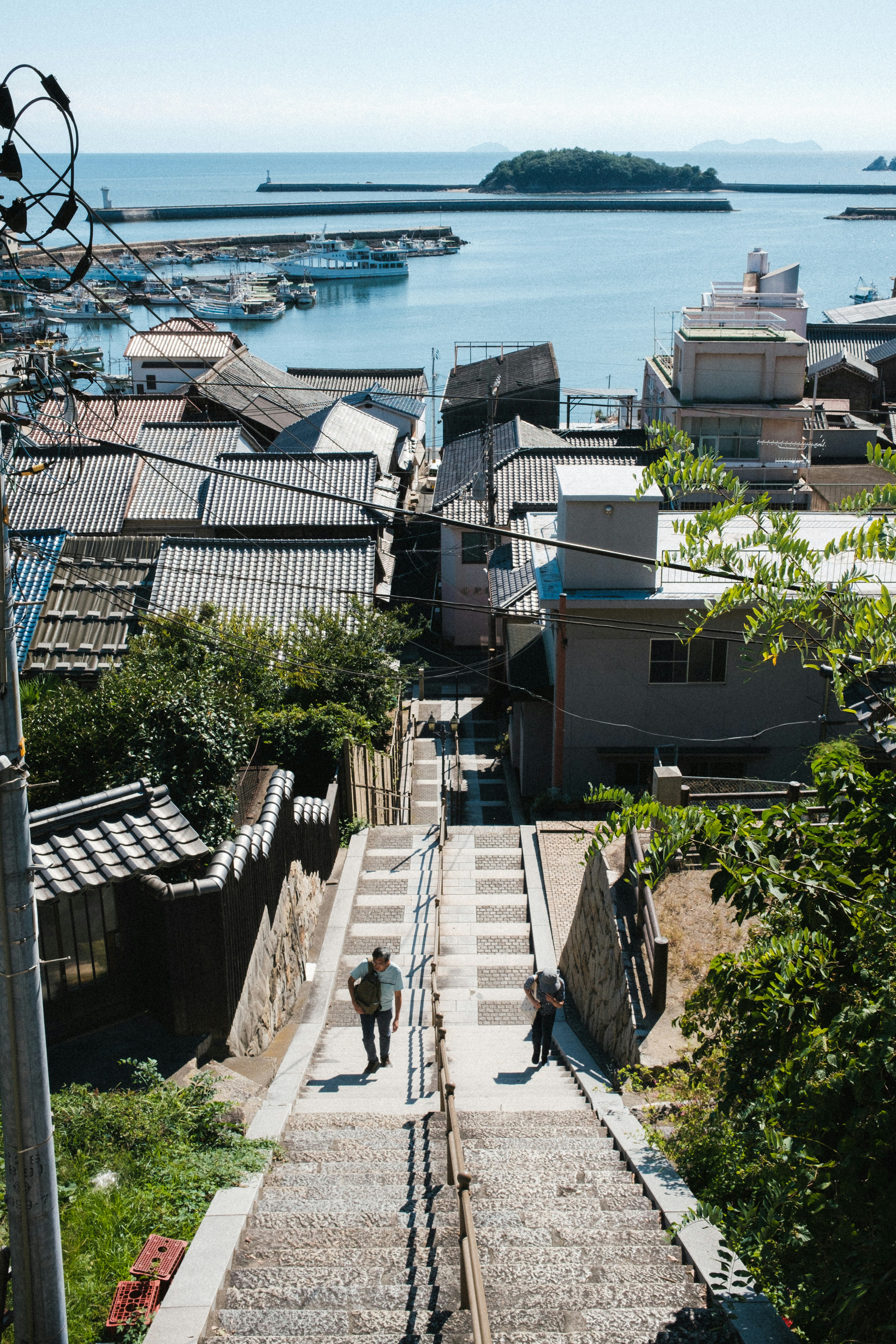 Escalera que desciende hacia el mar con casas antiguas a la vista