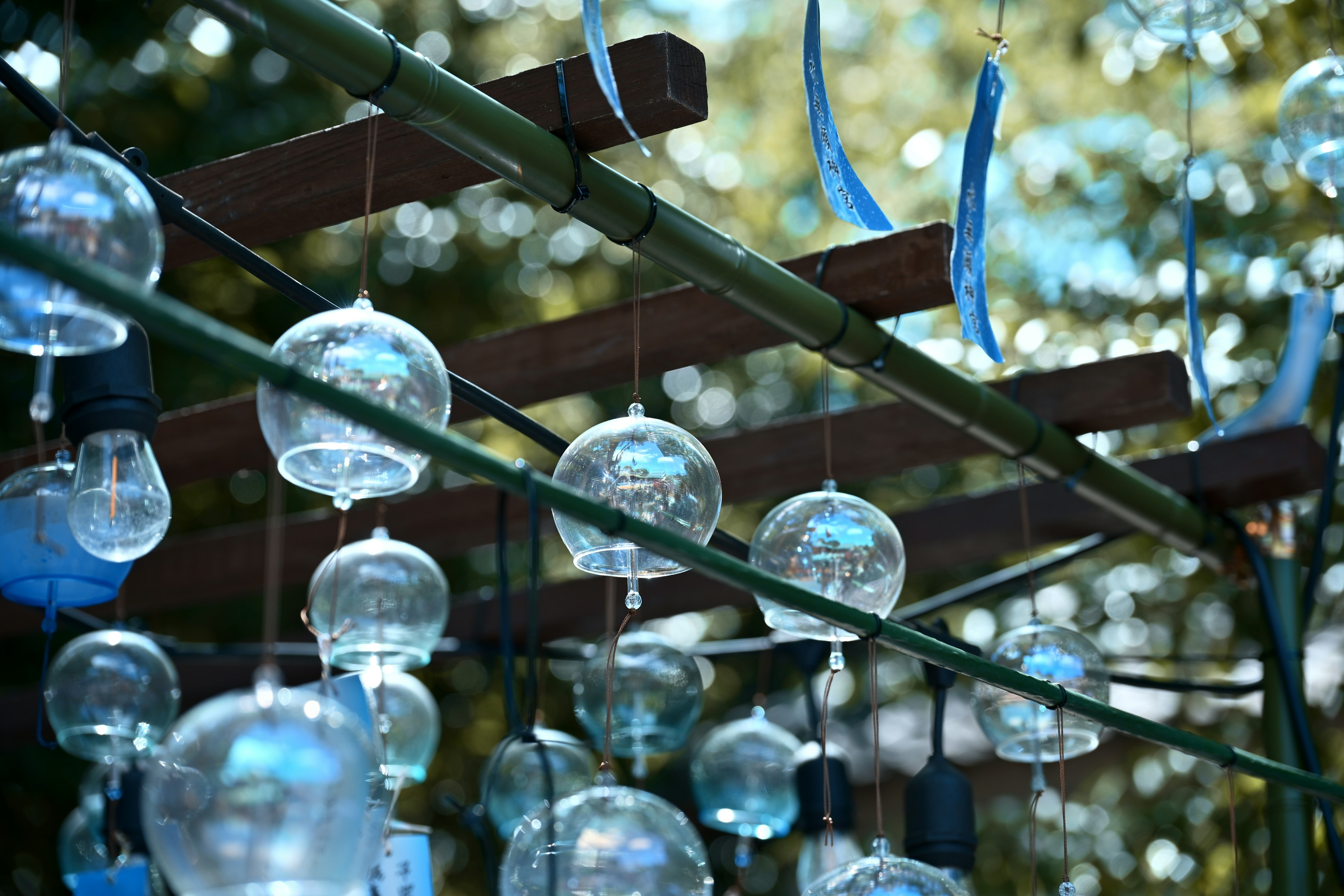 Blue wind chimes hanging from a bamboo rack