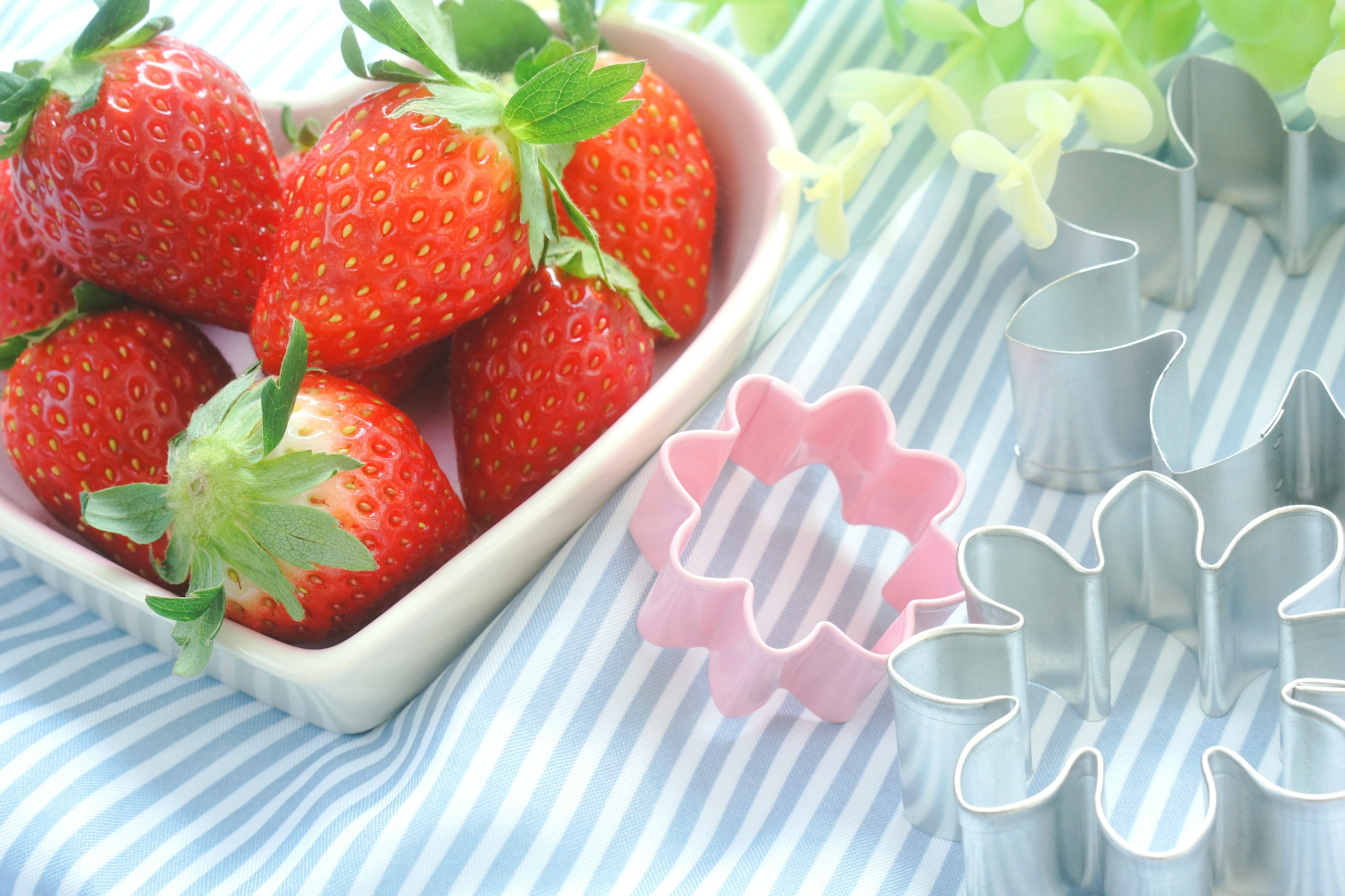 Fraises fraîches dans un plat en forme de cœur avec des emporte-pièces en forme de fleur