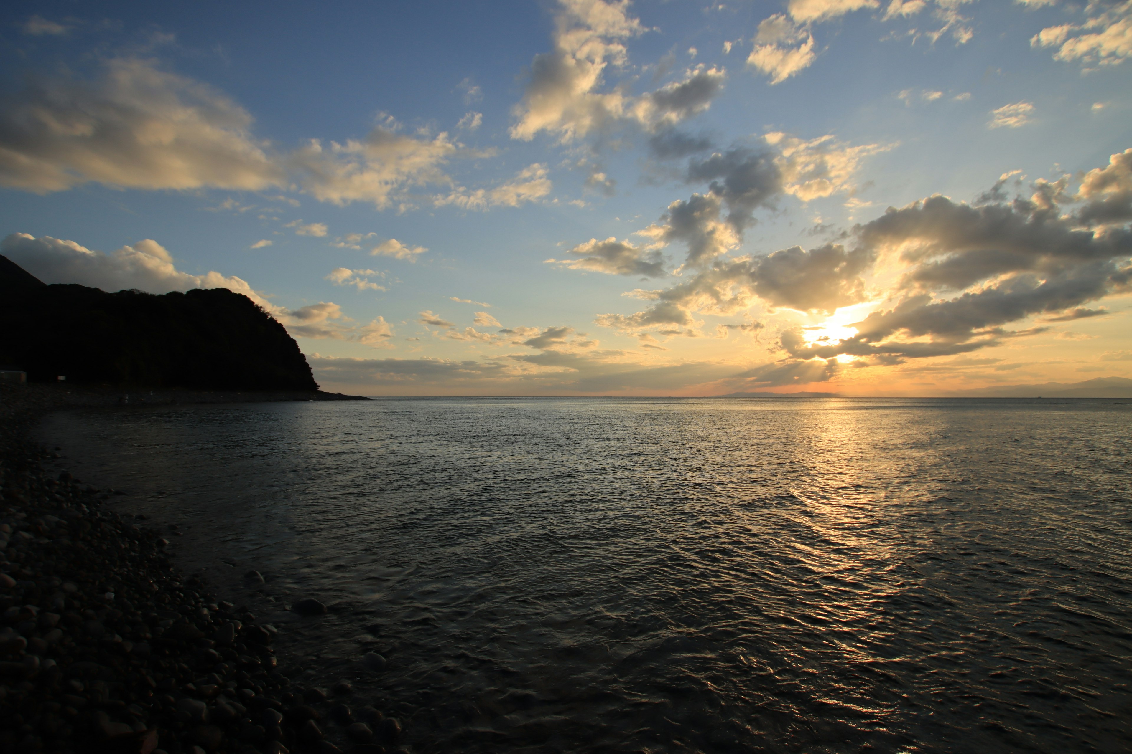 美麗的海上日落，平靜的波浪和散落的雲朵