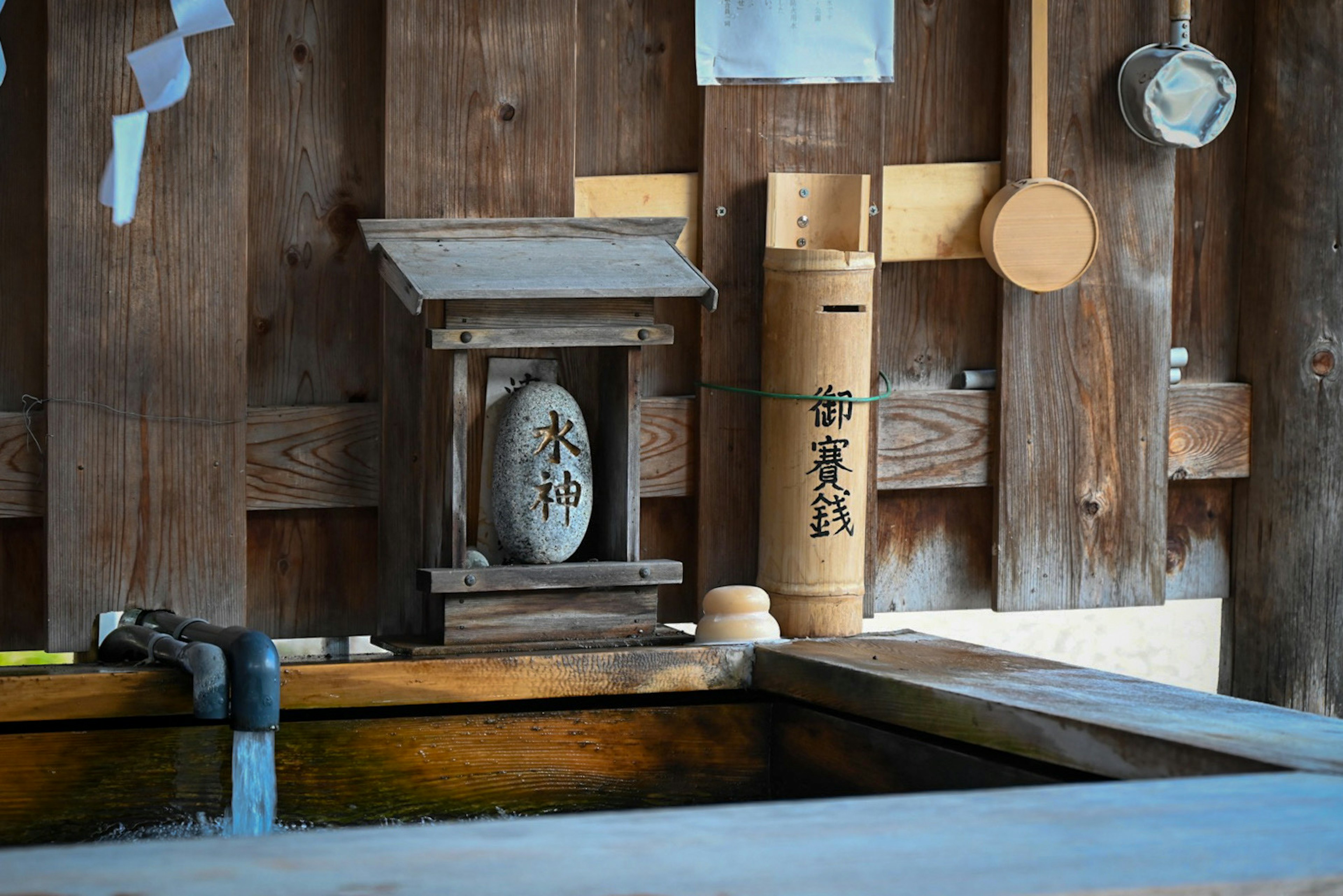 Interior tradisional Jepang dengan bak kayu dan patung dekoratif