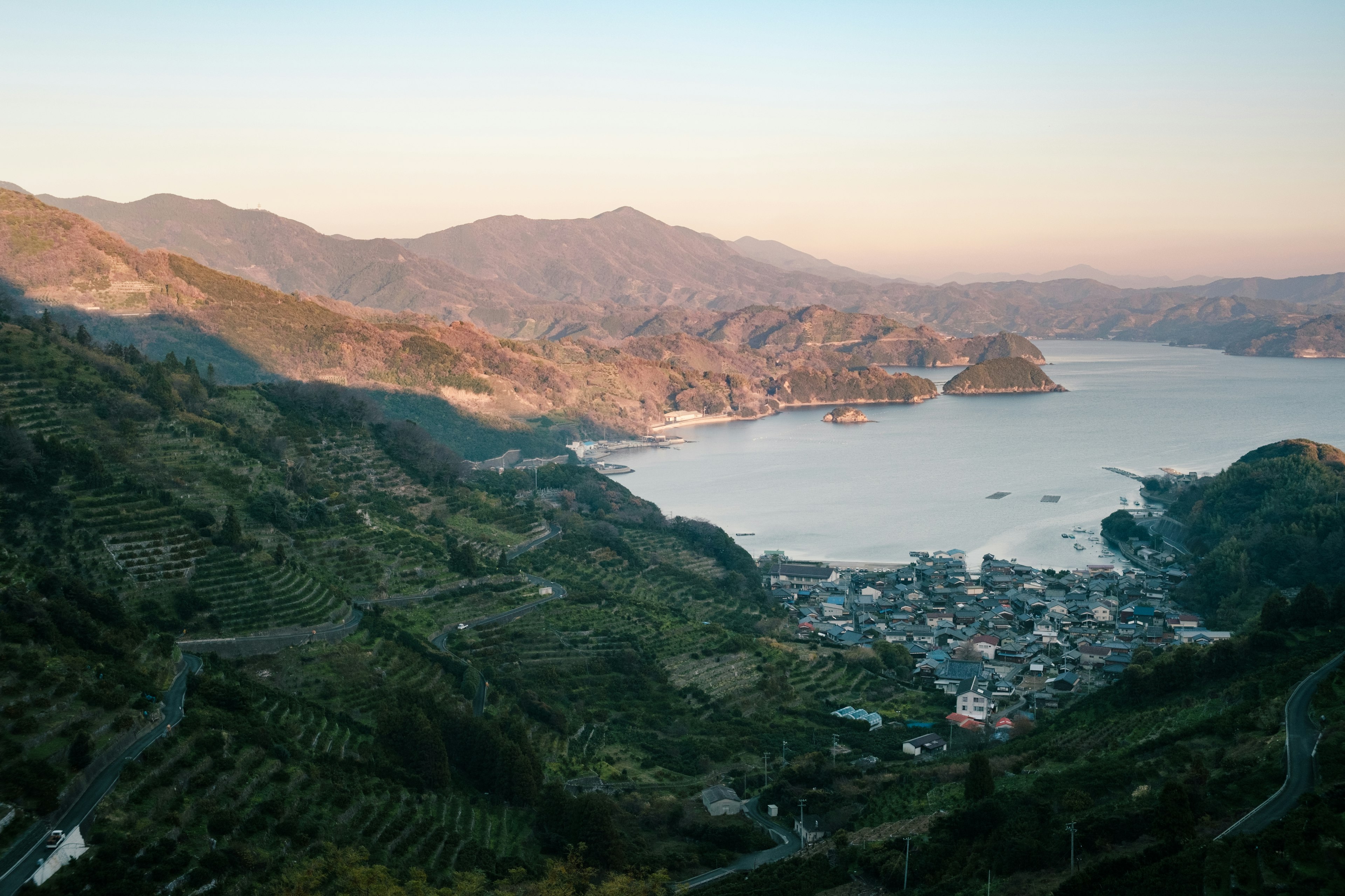 Vue panoramique des montagnes et d'une baie tranquille au coucher du soleil